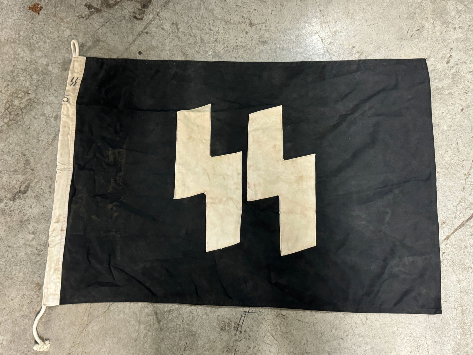 RARE WW2 GERMAN WAFFEN - SS FLAG FROM 5TH SS DIVISION: RARE WW2 GERMAN WAFFEN - SS FLAG FROM 5TH SS DIVISION. A SCARCE EXAMPLE. SHOWS GOOD WEAR AND USE WITH A BEAUTIFUL OVERALL PATINA. PLEASE VIEW ALL DETAILED PICTURES. A VERY RARE GERMAN ARTIFACT.