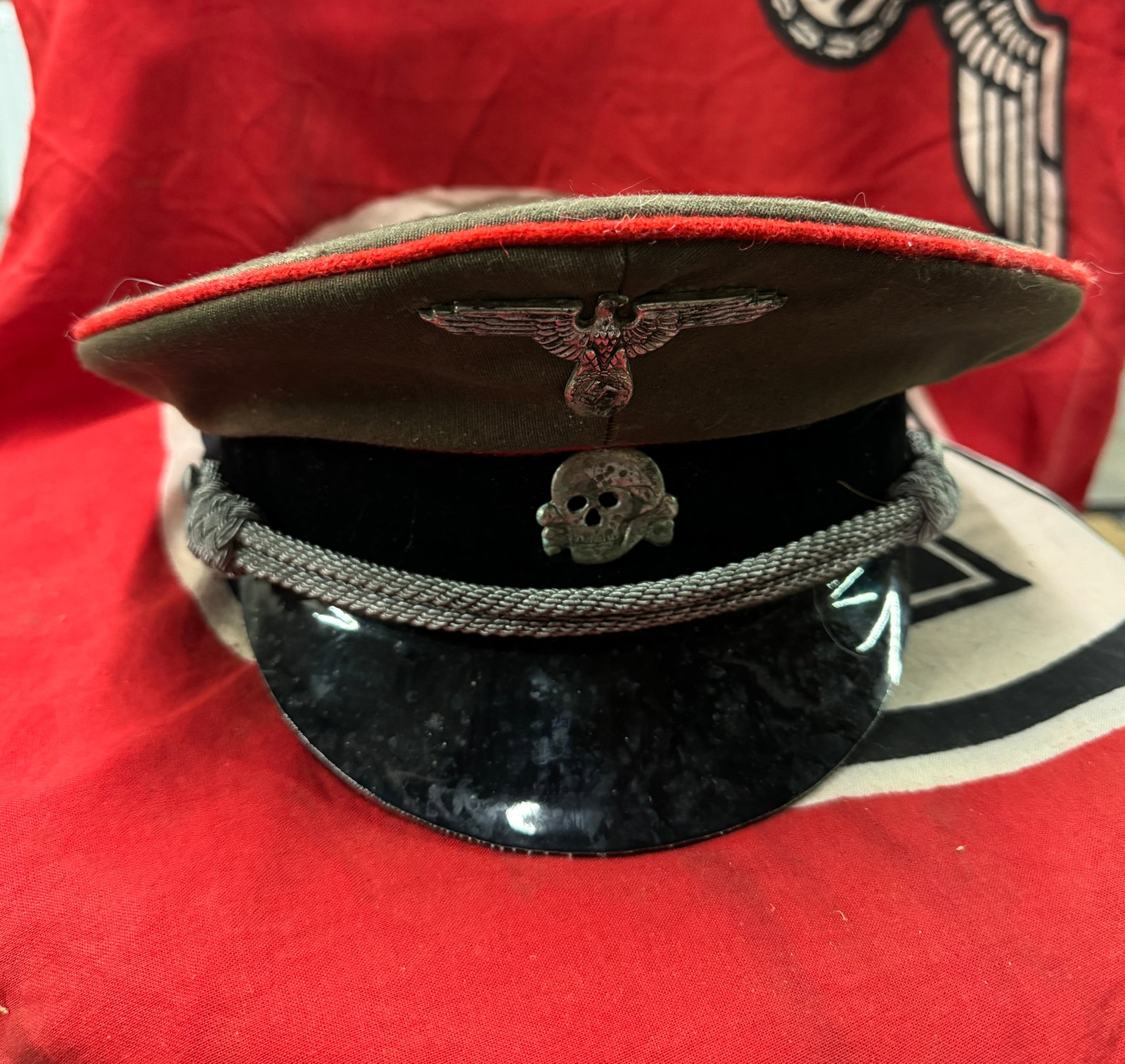 WW2 German Waffen SS Panzer Officer Visor Cap, Red Piped With RZM Paper Tag: WW2 German Waffen SS Panzer Officer Visor Cap, Red Piped With RZM Paper Tag. A VERY RARE FIND. SHOWS GOOD WEAR AND USE WITH A BEAUTIFUL OVERALL PATINA. APPEARS TO BE VERY WELL WORN. PLEASE VIEW ALL DE