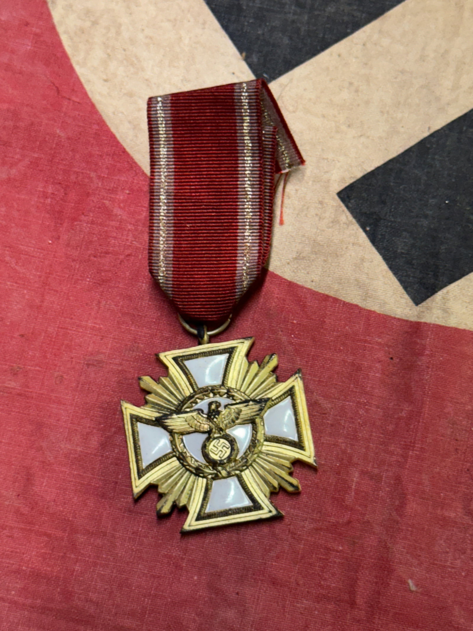 WW2 German NSDAP 25 Years Service Medal: WW2 German NSDAP 25 Years Service Medal. Die struck gold plated and enameled tombac, 3 pc construction, 43x43 mm, 38.6 gm with ribbon, ring not marked, 11 cm original red-white-gold rayon ribbon. In g