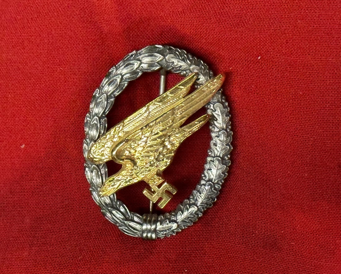 WW2 GERMAN FALLSCHIRMJÄGER BADGE BY CF JUNCKER: WW2 GERMAN FALLSCHIRMJÄGER BADGE BY CF JUNCKER. A RARE EXAMPLE. An early Luftwaffe Fallschirmjäger Badge silver nickle wreath with gilded tombac eagle. On the reverse, two visible rivets securing ea