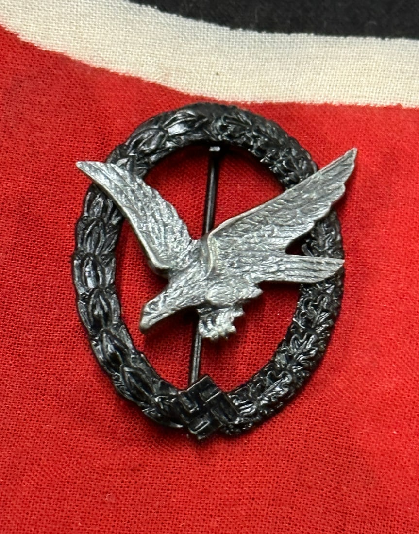 RARE WW2 GERMAN LUFTWAFFE AIRGUNNER BADGE: RARE WW2 GERMAN LUFTWAFFE AIRGUNNER BADGE. Zink constructed wreath with riveted zink eagle. Grey/antracite colored eagle. Rivets in good and tight condition and typical copper colored hinge and catch.