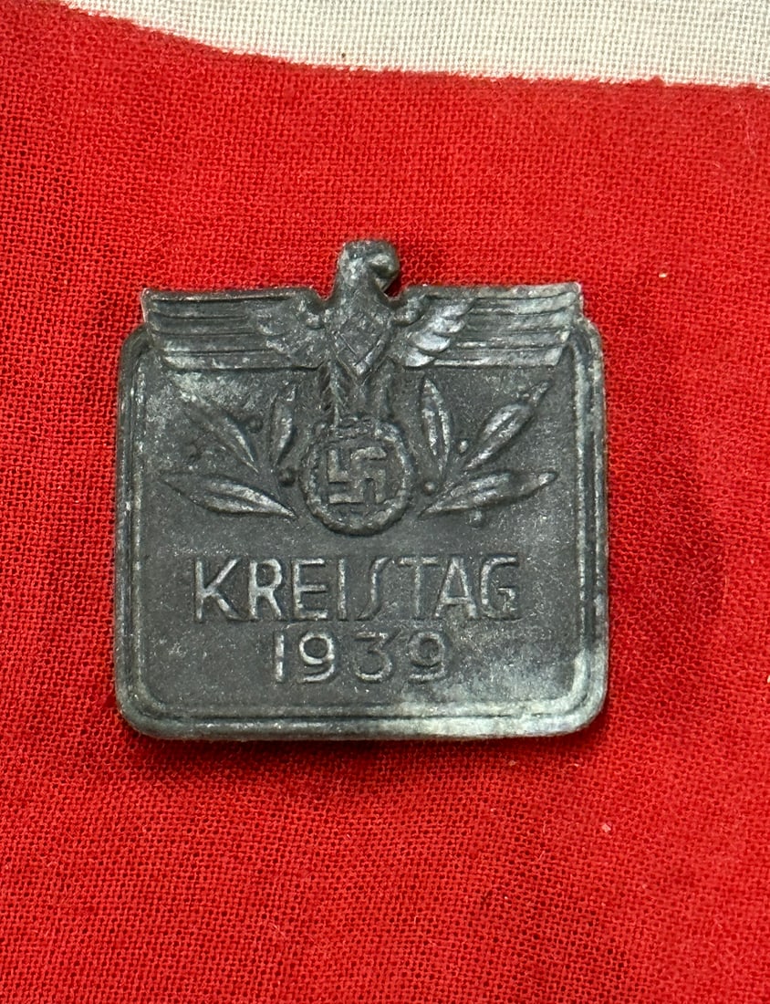 WW2 German Kreistag 1939 Tinnie: WW2 German Kreistag 1939 Tinnie. Zinc base tinnie with much corrosion. Marker marked on back Forester & Barth Pforzheim on back. Pin back.
