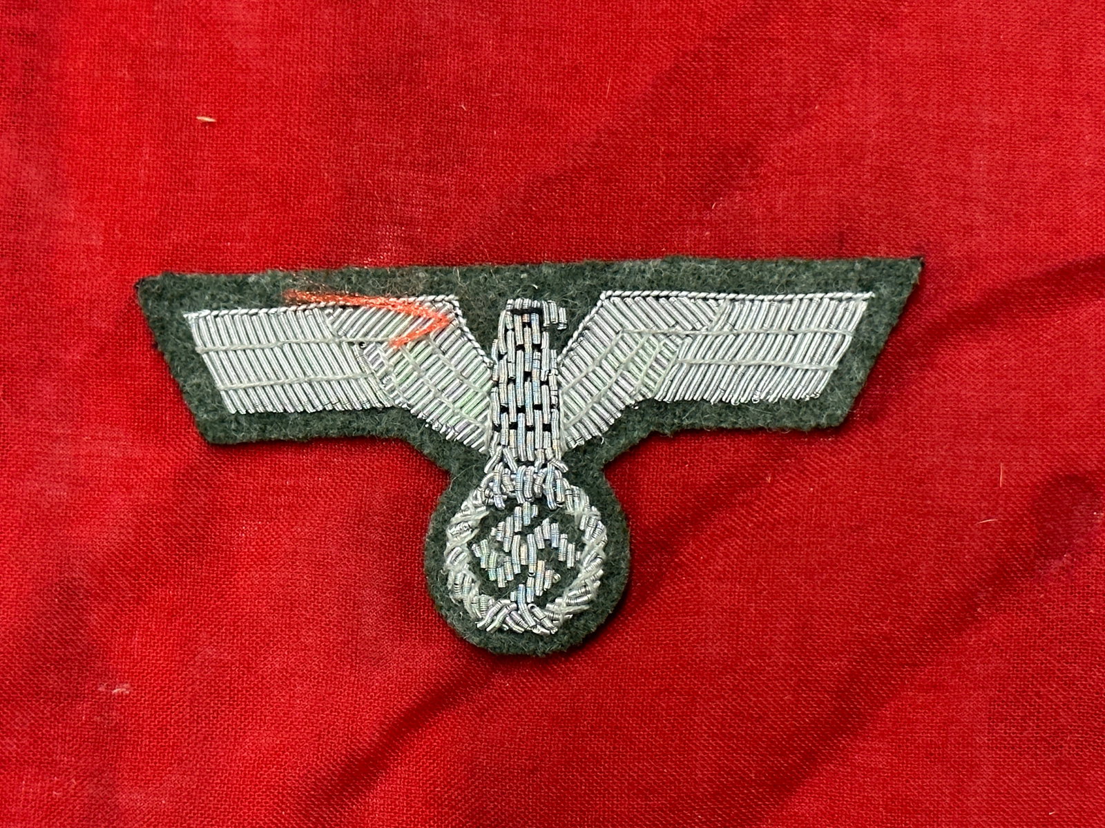 German WWII Army Officers Coat Eagle, Wire Embroidery: German WWII Army Officers Coat Eagle, Wire Embroidery. Original era manufacture. Silver wire embroidery on dark green wool badge cloth. A rare example. Please view all detailed pictures.