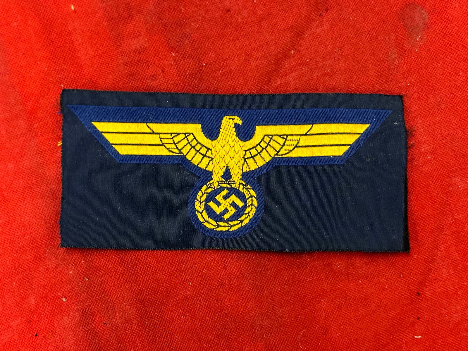 Mint Original German WWII Unissued Kriegsmarine (Navy) Breast Eagle: Original German WWII Unissued Kriegsmarine (Navy) Breast Eagle- Constructed of fine quality golden BeVo style machine embroidery on a dark woven background; with a blue rayon backer unissued condition
