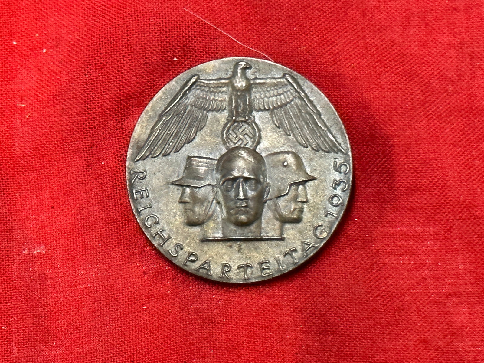 WW2 German Reichsparteitag 1935 Abzeichen Tinnie Badge: WW2 German Reichsparteitag 1935 Abzeichen Tinnie Badge. A scarce find. Shows good wear and use with a beautiful overall patina. Please view all detailed pictures. A scarce example.