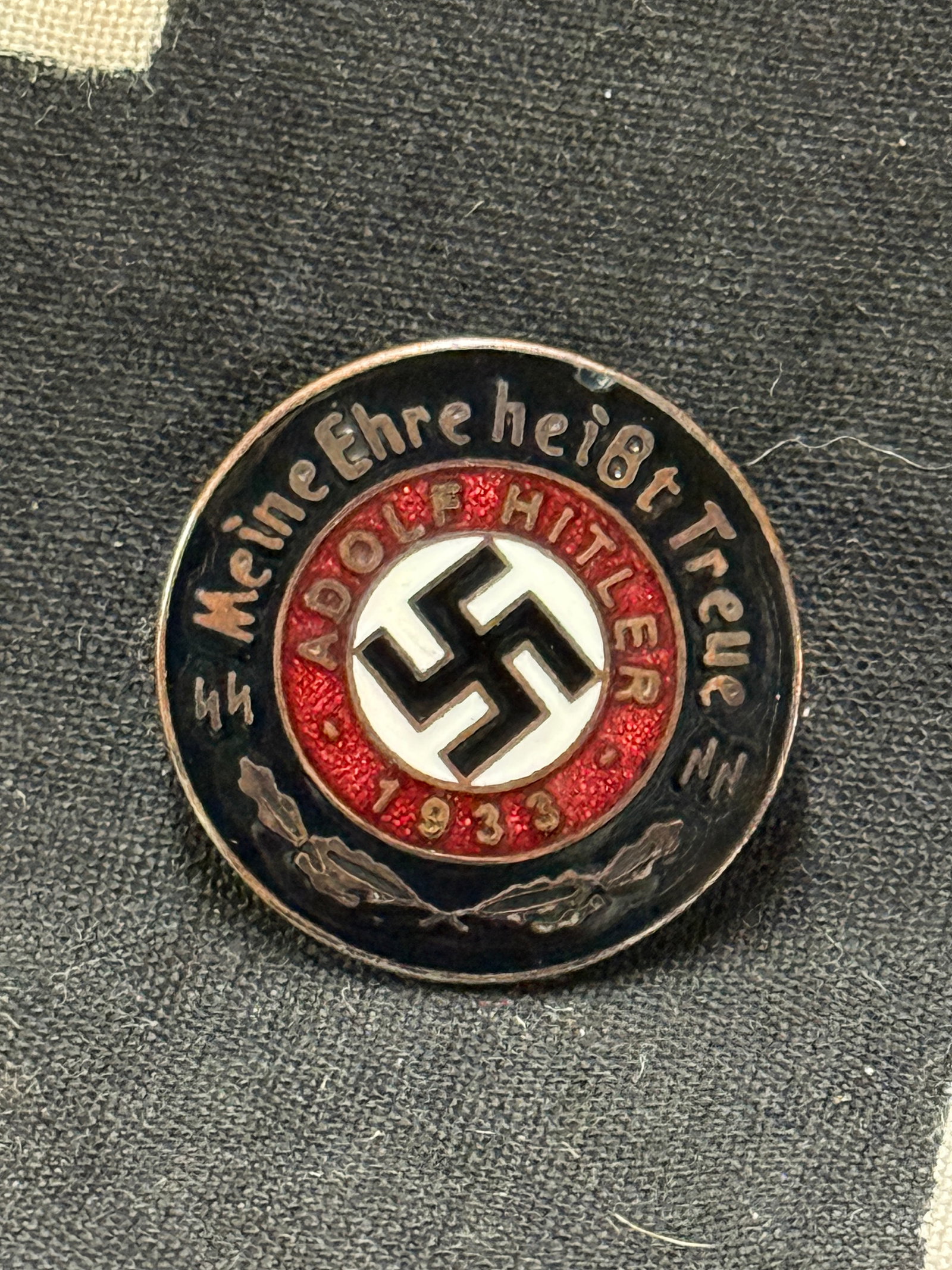 WW2 GERMAN WAFFEN SS ADOLF HITLER 1933 ENAMELED PARTY BADGE: WW2 GERMAN WAFFEN SS ADOLF HITLER 1933 ENAMELED PARTY BADGE. GESCH. RZM. A very scarce example that is in mint overall shape and condition with a beautiful overall patina. A rare find.