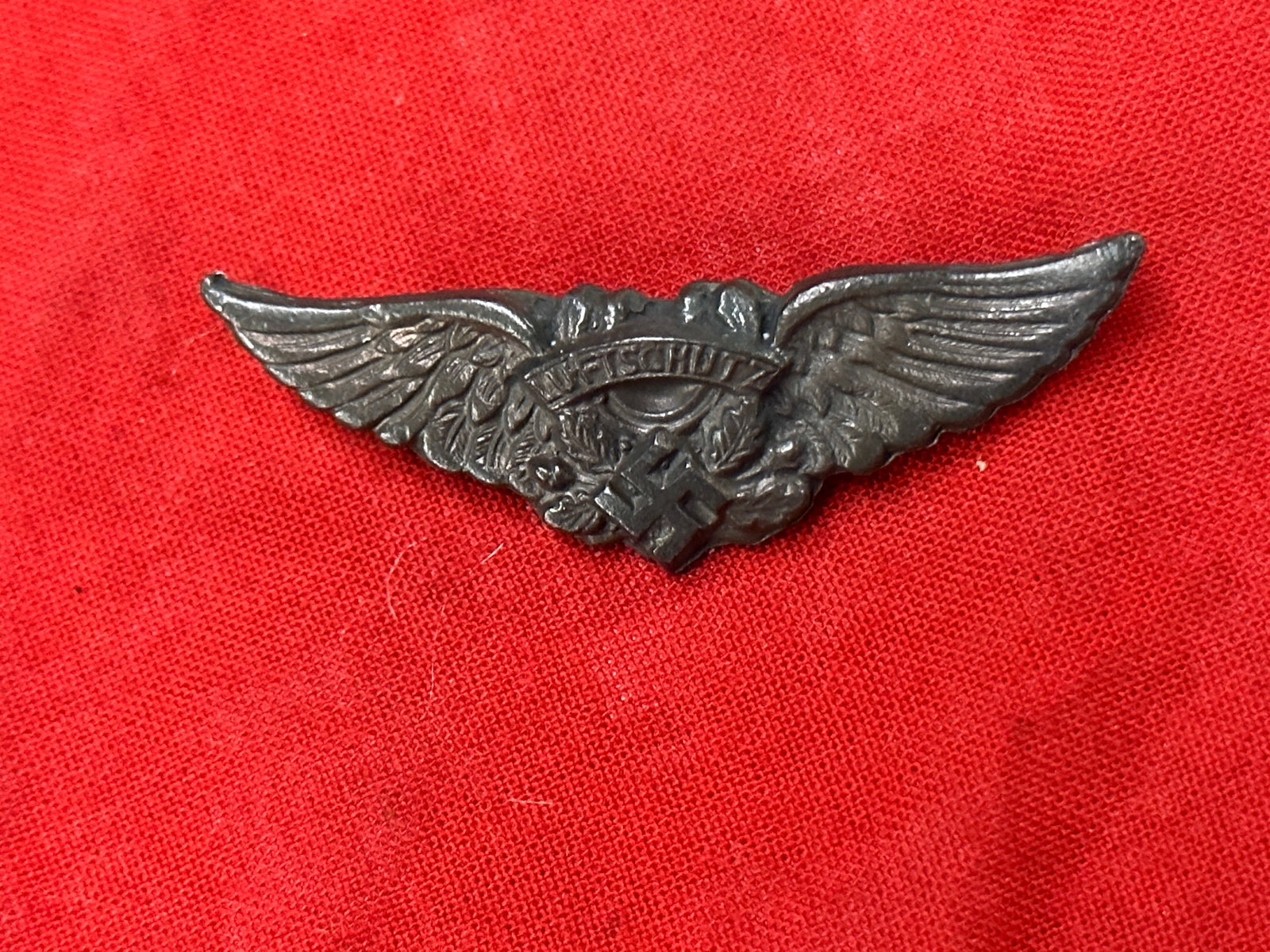 WW2 German “Luftschutz?? Insignia Cut from a Belt Buckle Made Into A Badge: WW2 German “Luftschutz” Insignia Cut from a Belt Buckle Made Into A Badge. Shows good wear and use with a beautiful overall patina. Please view all detailed pictures. A scarce find.