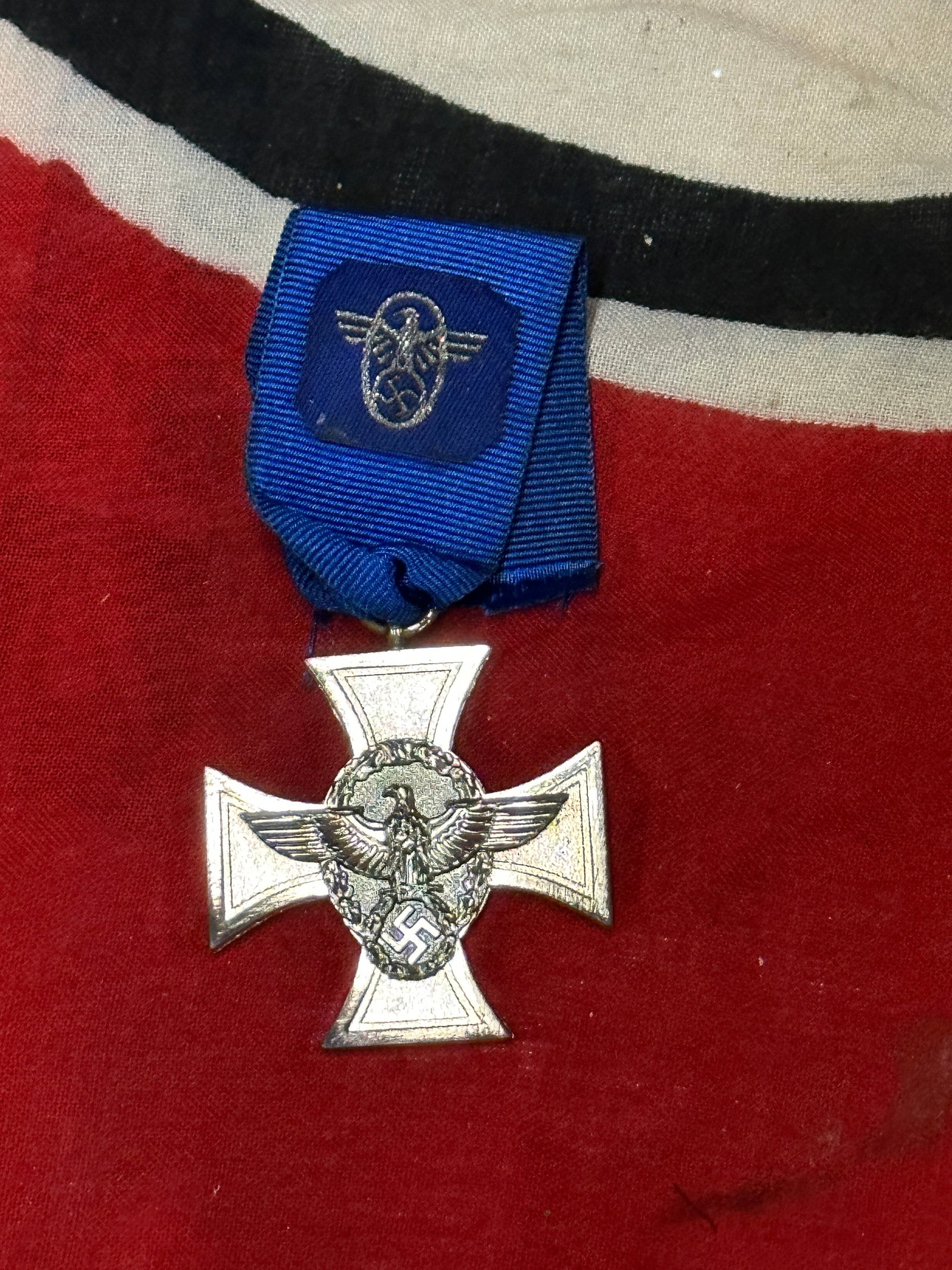 WW2 German Police Long Service Medal 18 Years: WW2 German Police Long Service Medal 18 Years. A WW2 German Police Long Service Medal 18 Years, constructed in silvered tombac with a period blue ribbon embroidered with police insignia. The obverse o