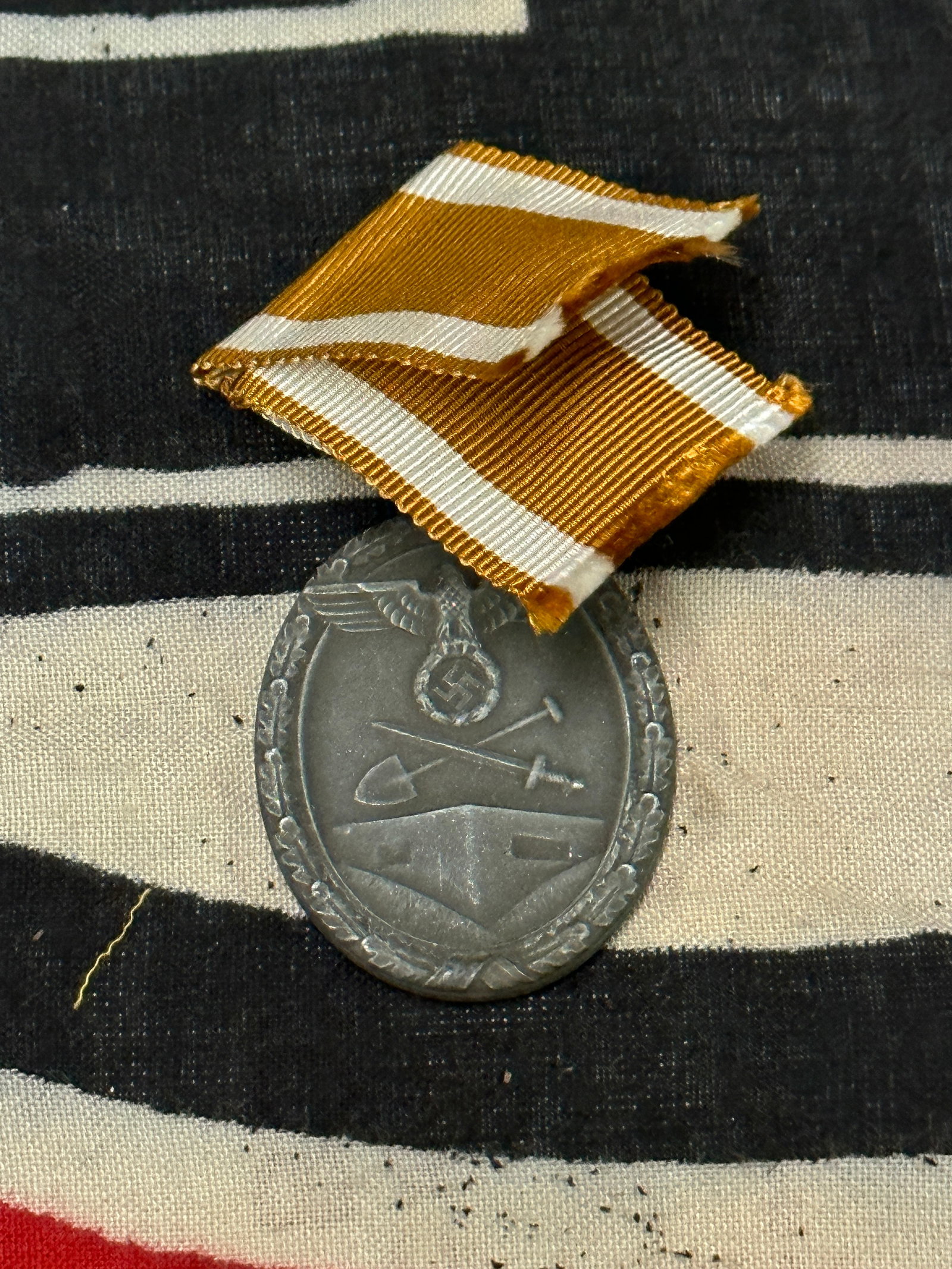 WW2 GERMAN WEST WALL MEDAL WITH RIBBON: WW2 GERMAN WEST WALL MEDAL WITH RIBBON. AN ULTRA RARE FIND THAT IS IN MINT OVERALL SHAPE AND CONDITION WITH A BEAUTIFUL OVERALL PATINA. PLEASE VIEW ALL DETAILED PICTURES. A SCARCE EXAMPLE.