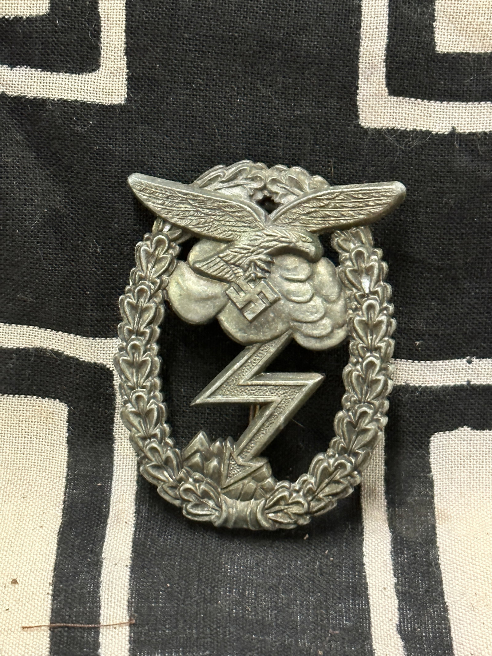 WW2 German Luftwaffe ground assult badge ‘Erdkampfabzeichen’ Maker Marked: WW2 German Luftwaffe ground assult badge ‘Erdkampfabzeichen’ Maker Marked on the reverse. Shows good wear and use with a beautiful overall patina. Zink late war construction, with the original thr