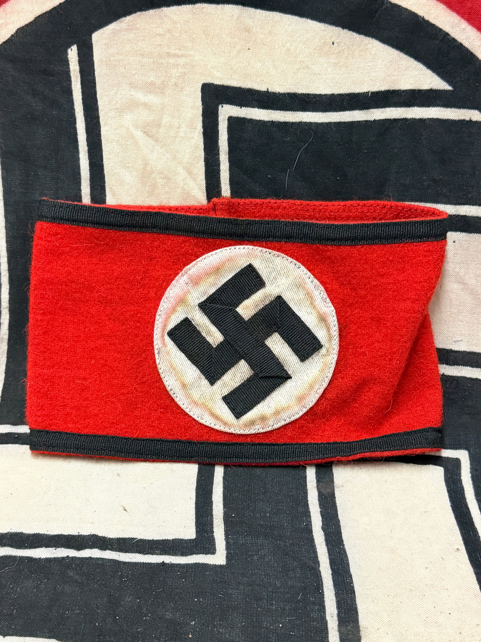 RARE WW2 GERMAN WAFFEN-SS ARMBAND WITH RZM TAG: RARE WW2 GERMAN WAFFEN-SS ARMBAND WITH RZM TAG. An SS Armband; RZM Tagged - Seven pieces of black rayon forming a swastika sewn upon a circular white rayon field in the centre, on a red wool armband, 