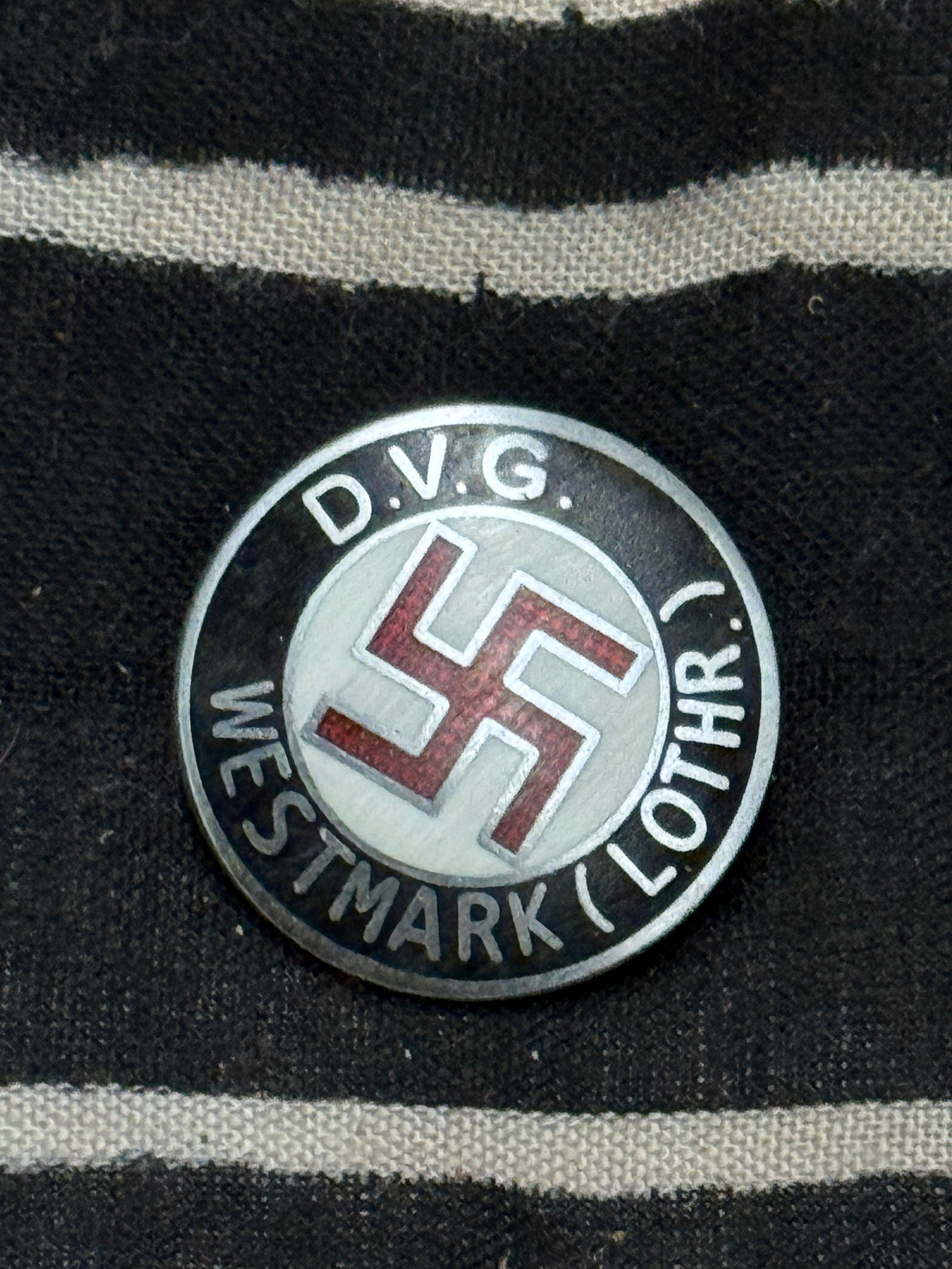 WW2 GERMAN D.V.G. WESTMARK (LOTHR) ENAMELED PIN BADGE BY W. REDO: WW2 GERMAN D.V.G. WESTMARK (LOTHR) ENAMELED PIN BADGE BY W. REDO. The badge is nicely maker marked W. REDO and SAARLAUTERN to the reverse in raised letters. The badge has no enamel damage and is a fin