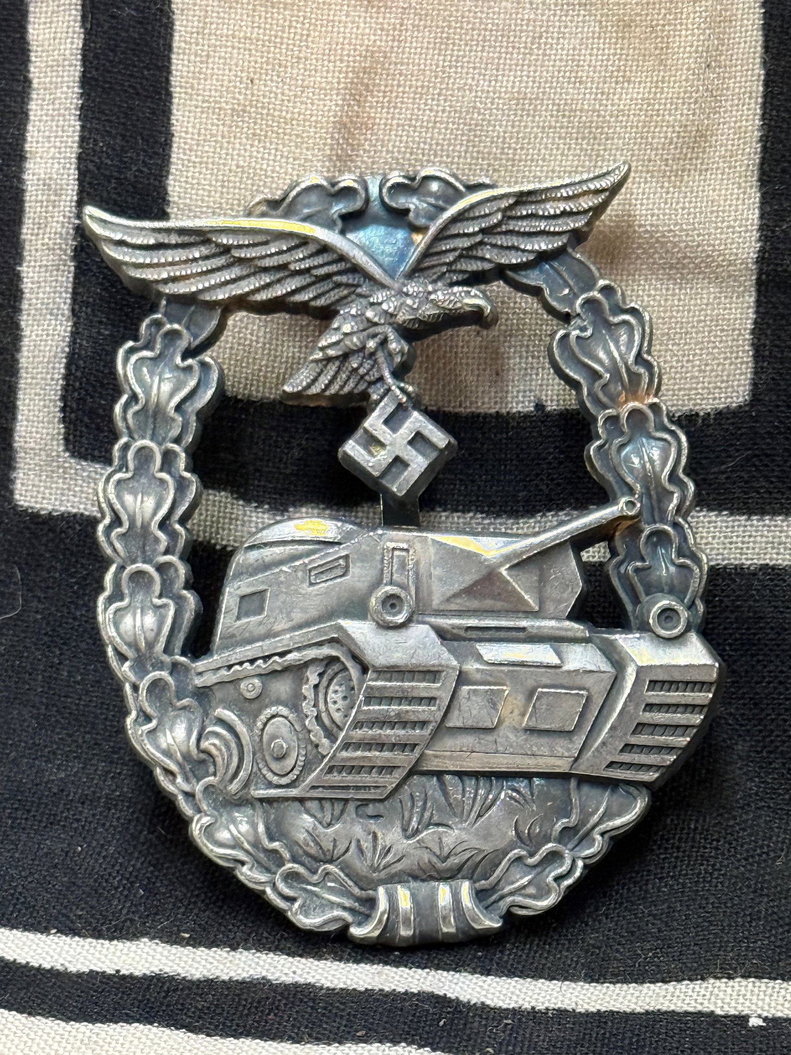 WW2 GERMAN LW LUFTWAFFE PANZER ASSAULT BADGE IN SILVER: WW2 GERMAN LW LUFTWAFFE PANZER ASSAULT BADGE IN SILVER. RARE LATE WAR UNMARKED LW PANZER ASSAULT BADGE FOR “HERMAN GORING “ DIVISION. This is really in super great shape other than the aging that 