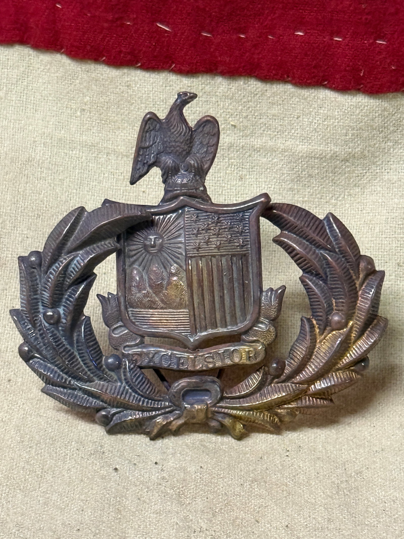 CIVIL WAR NEW YORK STATE EXCELSIOR HEADGEAR BADGE INSIGNIA: CIVIL WAR NEW YORK STATE EXCELSIOR HEADGEAR BADGE INSIGNIA. A VERY RARE FIND. SHOWS GOOD WEAR AND USE WITH A BEAUTIFUL OVERALL PATINA. HAS A GREAT LOOK TO IT WITH AN EXCELLENT OVERALL EYE APPEAL. PLEA