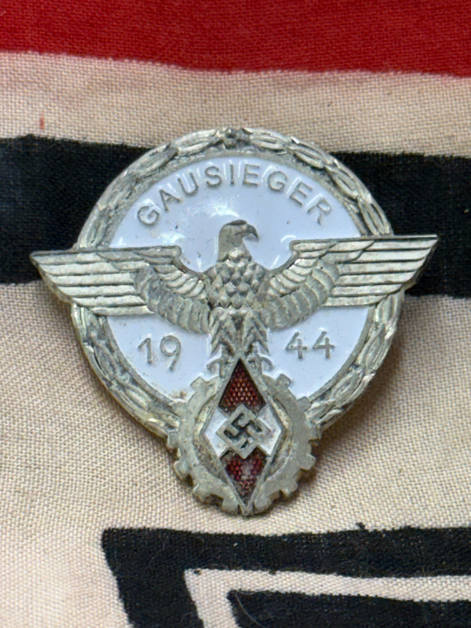 WW2 German Third Reich 1944 HJ Gausieger Award Badge By G. Brehmer Markneukirchen: WW2 German Third Reich 1944 HJ Gausieger Award Badge By G. Brehmer Markneukirchen. A rare find. Shows good wear and use with a beautiful overall patina. Please view all detailed pictures. A scarce exa