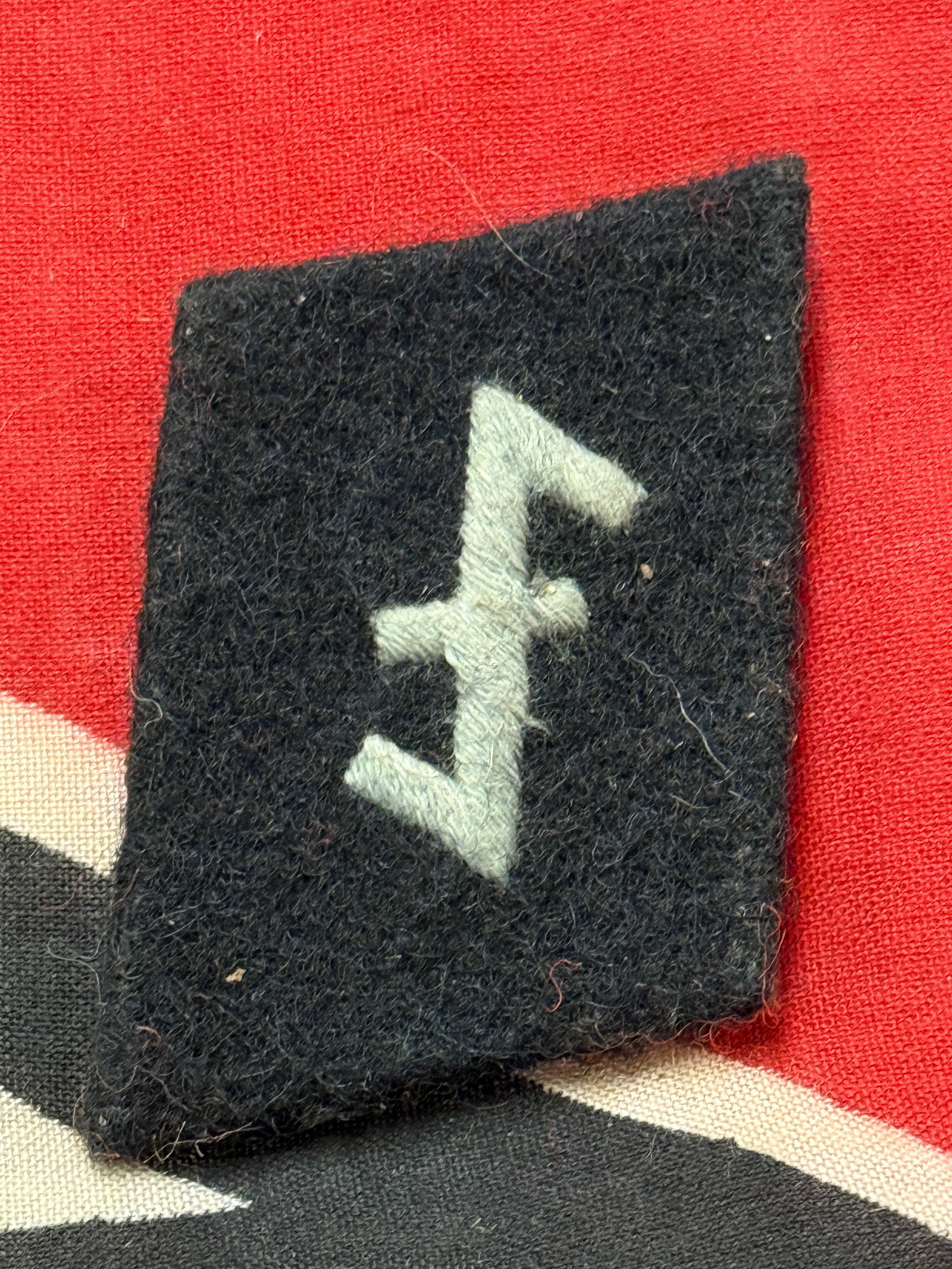 WW2 GERMAN WOLF HOOK NEDERLAND COLLAR TAB BY RZM WITH PAPER TAG: WW2 GERMAN WOLF HOOK NEDERLAND COLLAR TAB BY RZM WITH PAPER TAG. A VERY RARE EXAMPLE THAT IS IN MINT OVERALL SHAPE AND CONDITION WITH A BEAUTIFUL OVERALL PATINA. HAS THE ORIGINAL MAKER MARKED RZM PAPE