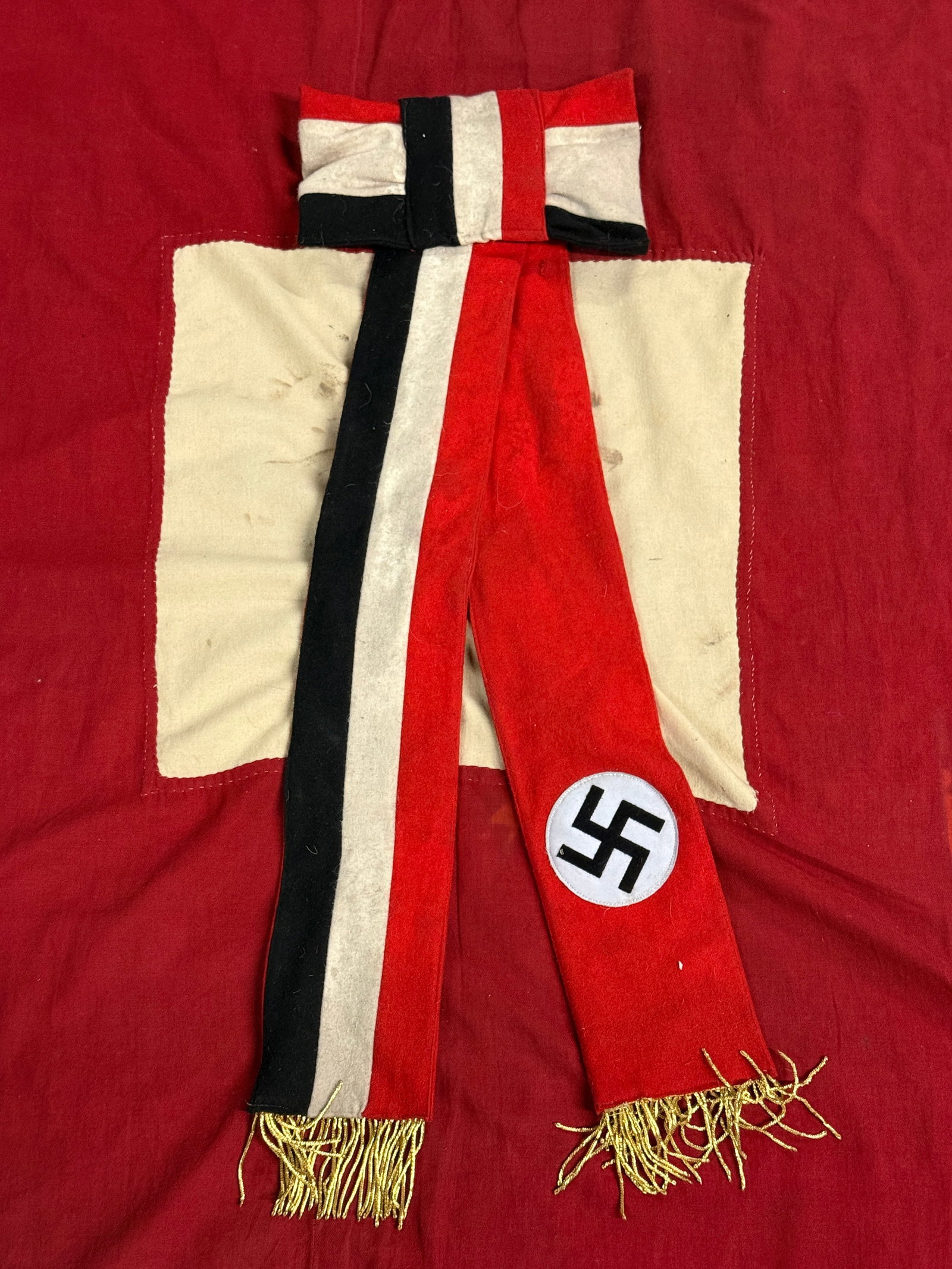 WW2 GERMAN NSDAP BOW FOR FUNERARY WREATH WITH RZM PAPER TAG: WW2 GERMAN NSDAP BOW FOR FUNERARY WREATH. This cotton bow was affixed to funeral wreaths. The two hanging end of the bow display the national colors on one end and the red swastika disc on the other. 