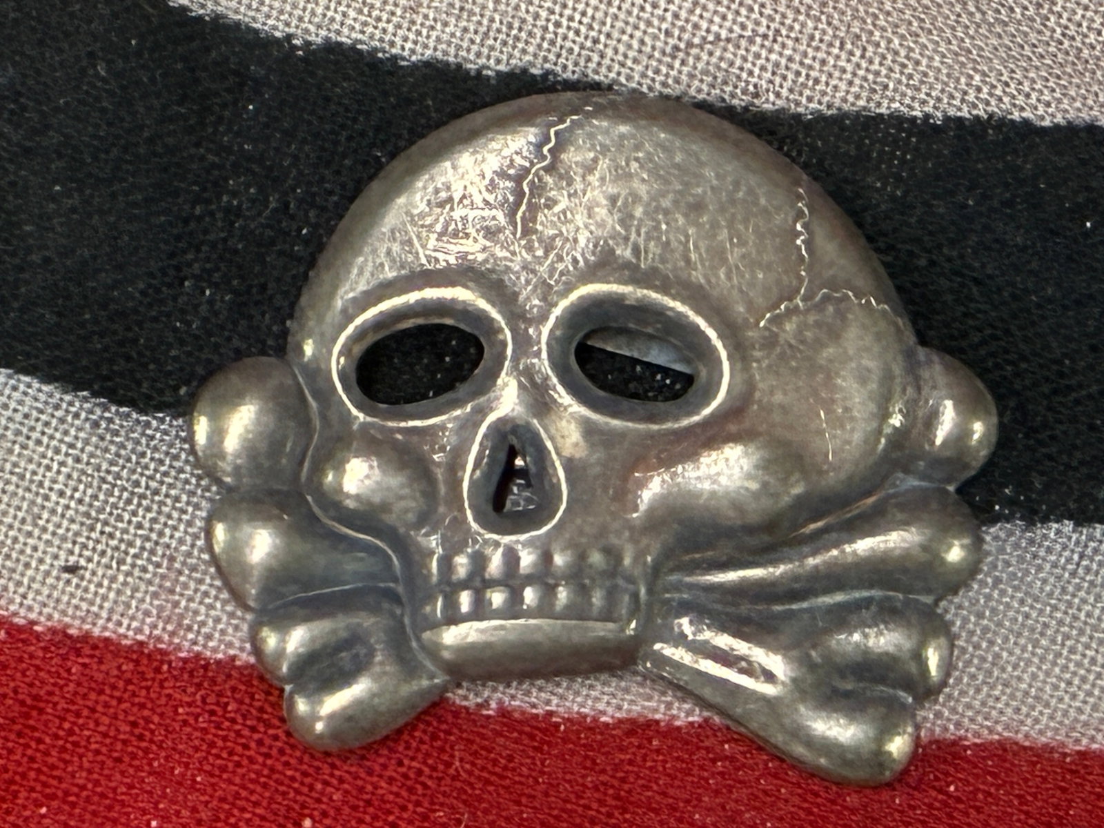 EARLY WW2 GERMAN TOTENKOPF SKULL HEADGEAR BADGE: EARLY WW2 GERMAN TOTENKOPF SKULL HEADGEAR BADGE. A RARE FIND. SHOWS GOOD WEAR AND USE WITH A BEAUTIFUL OVERALL PATINA. PLEASE VIEW ALL DETAILED PICTURES. A VERY RARE EXAMPLE.