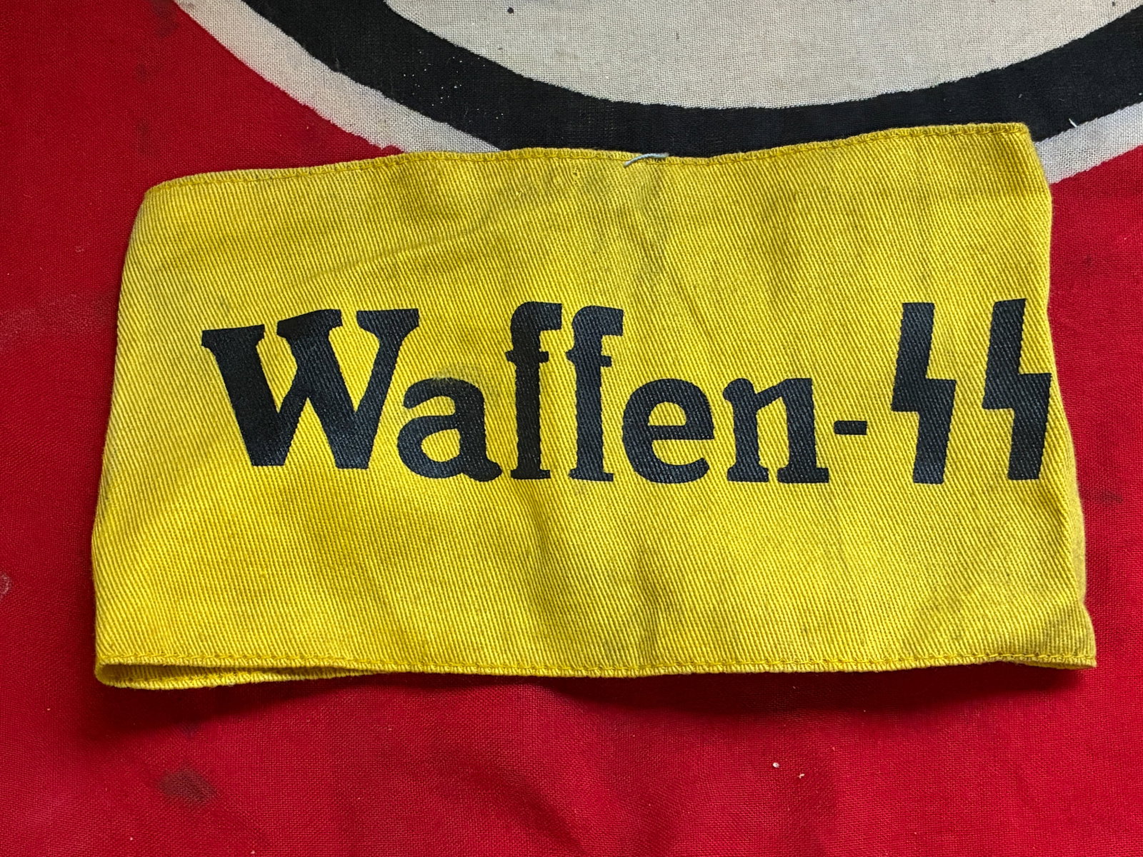 WW2 German Waffen SS Auxilliary Armband With RZM Paper Tag: WW2 German Waffen SS Auxilliary Armband With RZM Paper Tag. Sewn cotton construction with printed "Waffen-SS" in black. Good condition with light wear.