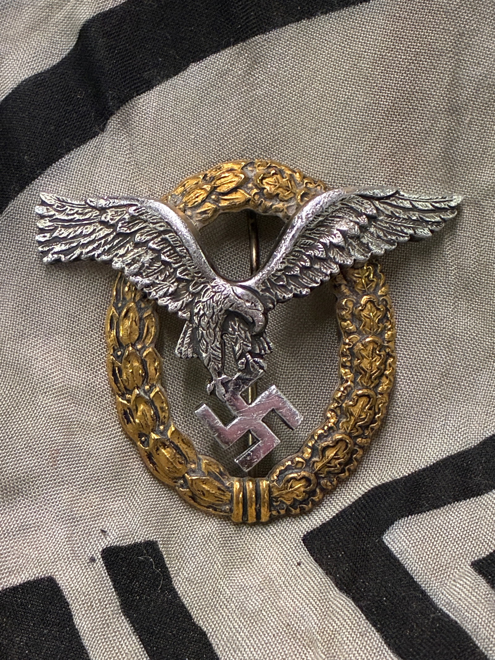 German WWII Luftwaffe Pilot Observer Badge - Maker Marked: German WWII Luftwaffe Pilot Observer Badge - Maker Marked. It is die-struck from alloy, featuring a two-piece construction. The eagle is securely affixed to the wreath with two small dome-headed rivet