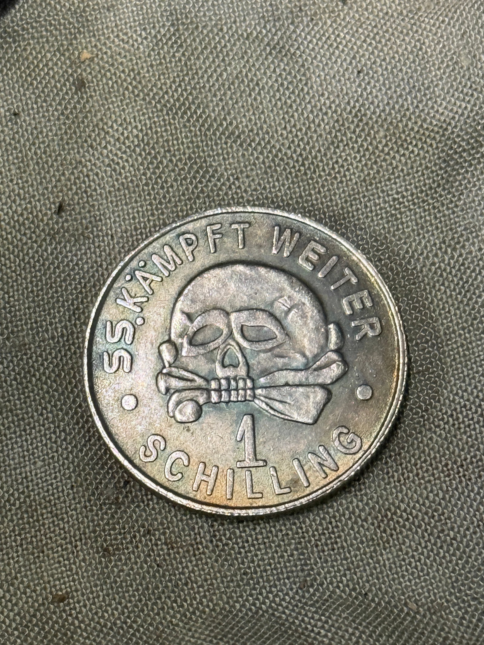 RARE WW2 GERMAN TOTENKOPF SS KAMPFT WEITER 1 SCHILLING SILVER COIN: RARE WW2 GERMAN TOTENKOPF SS KAMPFT WEITER 1 SCHILLING SILVER COIN. A RARE FIND. SHOWS GOOD WEAR AND USE WITH A BEAUTIFUL OVERALL PATINA. PLEASE VIEW ALL DETAILED PICTURES. A RARE EXAMPLE OF THE TIME 