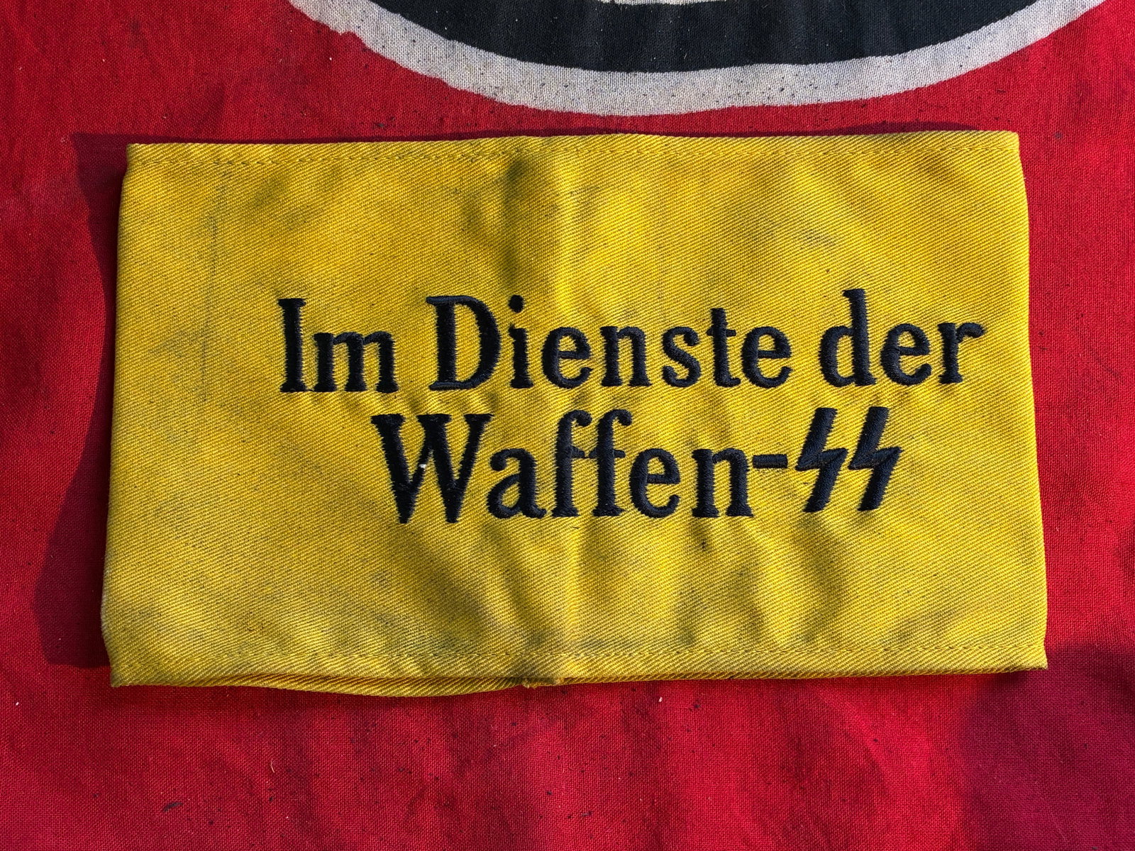 WW2 German armband "Im Dienste der Waffen-SS" With RZM Paper Tag: WW2 German armband "Im Dienste der Waffen-SS" With RZM Paper Tag. A VERY RARE FIND. SHOWS GOOD WEAR AND USE WITH A BEUATIFUL OVERALL PATINA. HAS STAINING AND A FEW MARKS BUT IN EXCEPTIONAL CONDITION. 