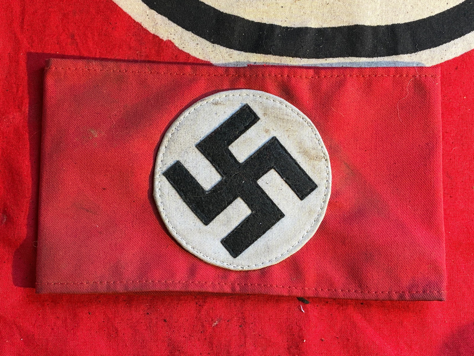 SCARCE WW2 GERMAN NSDAP TUNIC ARMBAND WITH RZM SA PAPER TAG: SCARCE WW2 GERMAN NSDAP TUNIC ARMBAND WITH RZM SA PAPER TAG. A VERY RARE FIND. SHOWS GOOD WEAR AND USE WITH A BEUATIFUL OVERALL PATINA. HAS STAINING AND A FEW MARKS BUT IN EXCEPTIONAL CONDITION. INTAC
