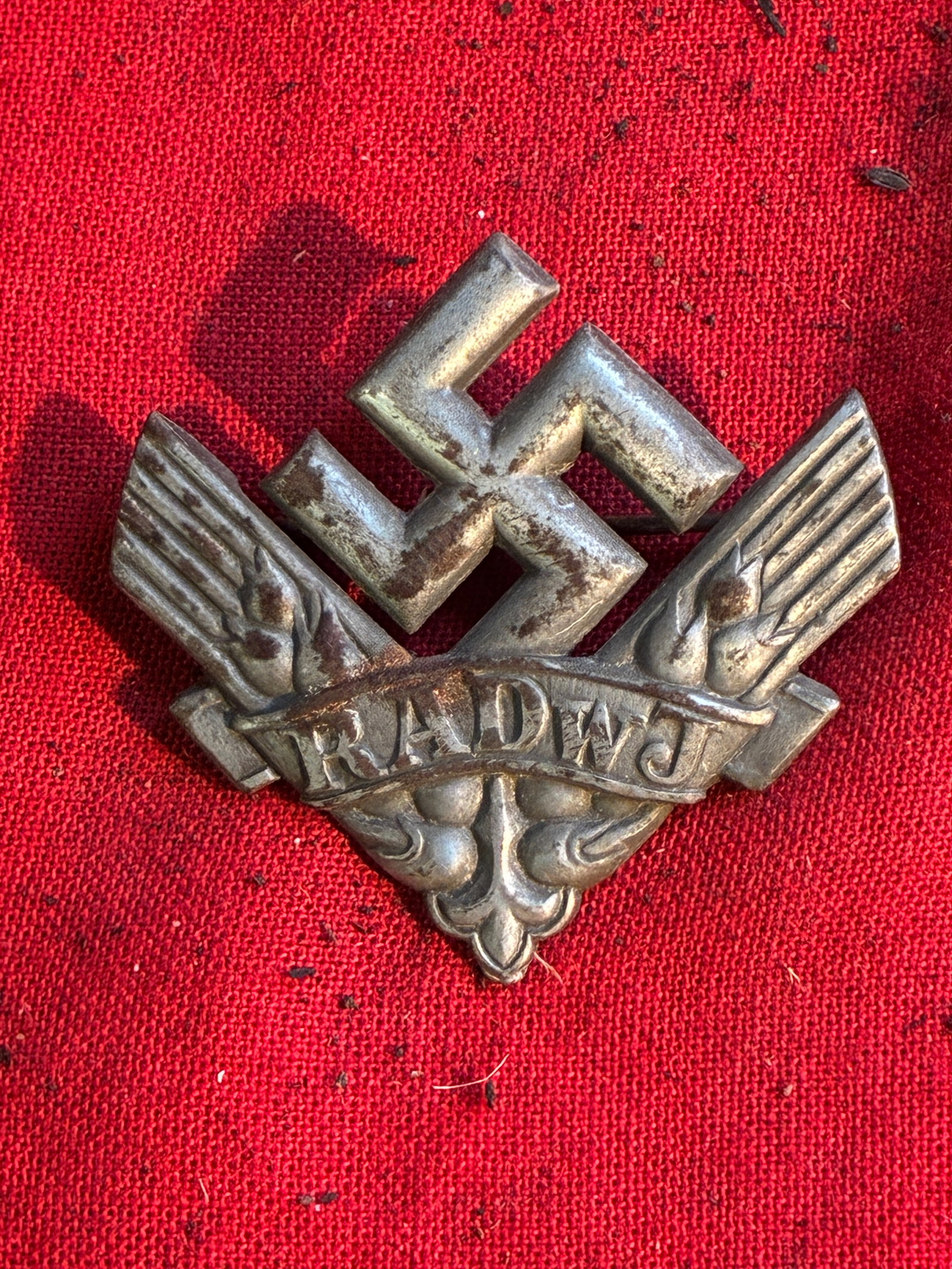 WW2 German RAD RADwJ Membership Badge: WW2 German RAD RADwJ Membership Badge. Badge is in silvered grey metal, horizontal pinback with catch - missing, unmarked hollow back, measuring 39 mm x 38 mm, much of its original silver finish remai