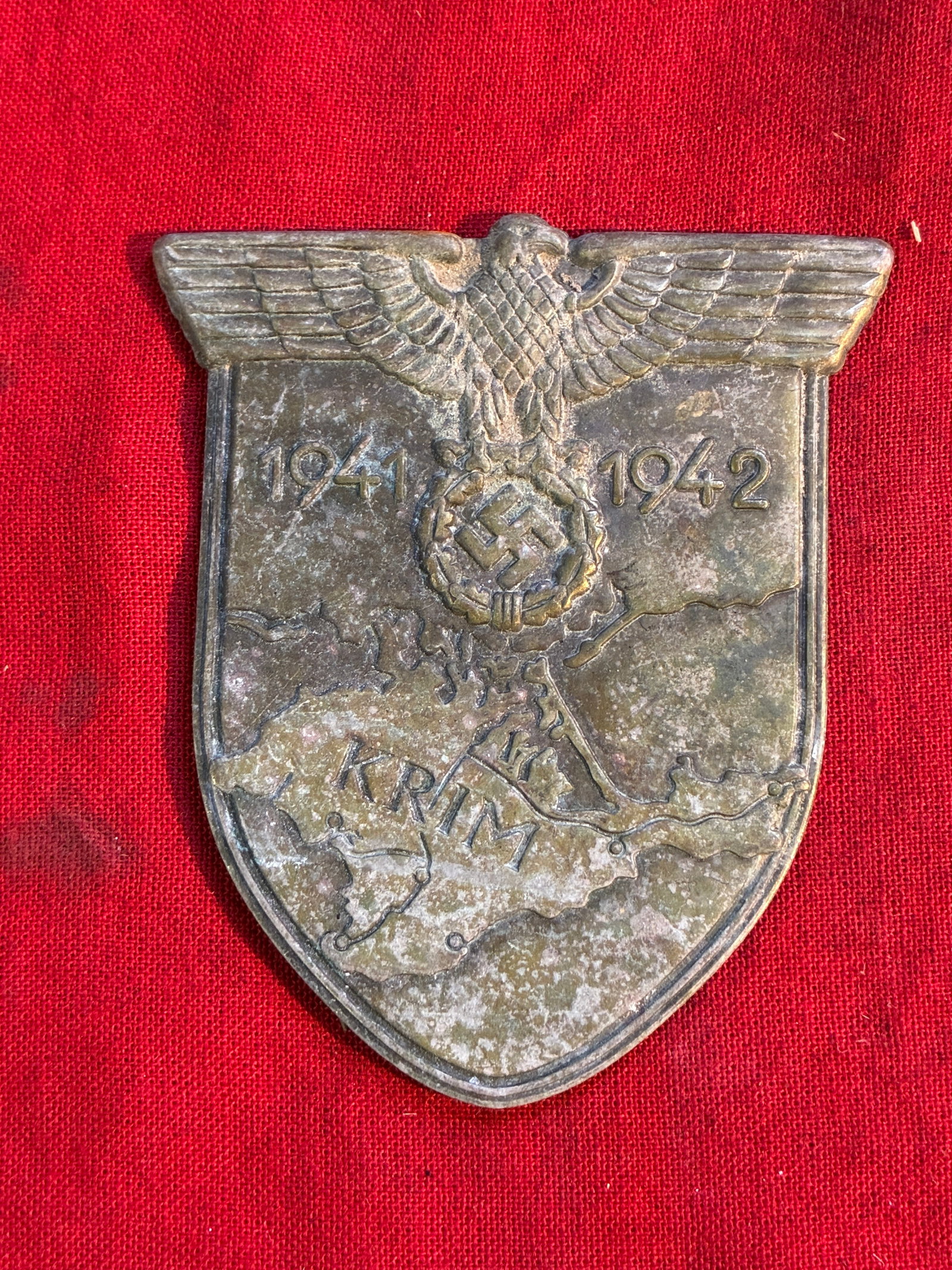 RARE WW2 GERMAN KRIM SLEEVE SHIELD IN ZINC: RARE WW2 GERMAN KRIM SLEEVE SHIELD IN ZINC. A RARE FIND. NO MISSING PRONGS ON THE REVERSE. SHOWS GOOD WEAR AND USE WITH A BEAUTIFUL PATINA THROUGHOUT. PLEASE VIEW ALL DETAILED PICTURES. A WELL MADE AN