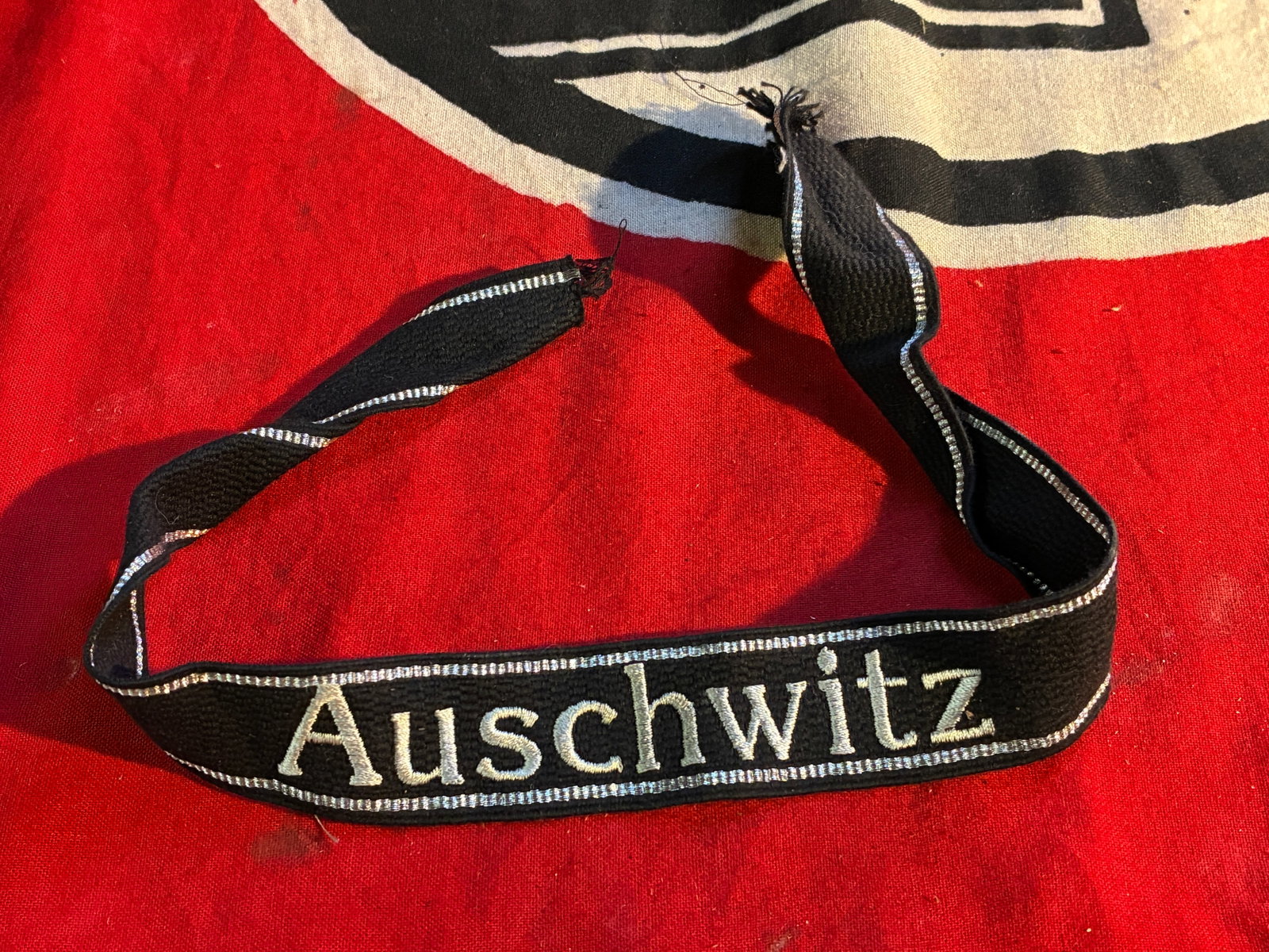 WW2 German Auschwitz Cuff Title w/hand embroidered metallic lettering & border: WW2 German Auschwitz Cuff Title w/hand embroidered metallic lettering & border. A rare find. Shows good wear and use with a beautiful overall patina. Please view all detailed pictures. A scarce exampl