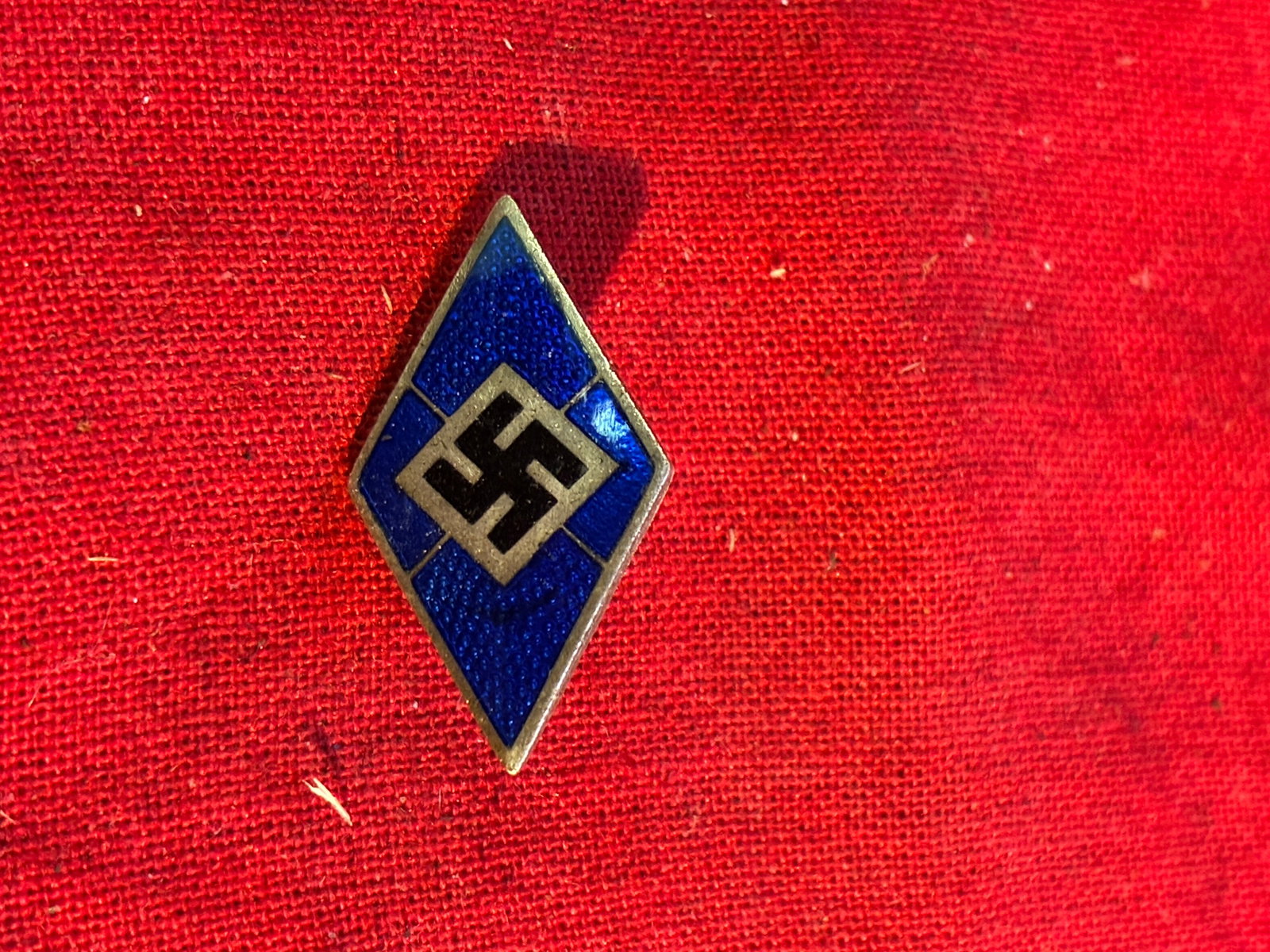 WW2 GERMAN HJ HITLER YOUTH DIAMOND ENAMELED CAP BADGE IN BLUE BY GES. GESCH.: WW2 GERMAN HJ HITLER YOUTH DIAMOND ENAMELED CAP BADGE IN BLUE BY GES. GESCH. A RARE FIND. SHOWS GOOD WEAR AND USE WITH A BEAUTIFUL OVERALL PATINA. PLEASE VIEW ALL DETAILED PICTURES. A SCARCE EXAMPLE.
