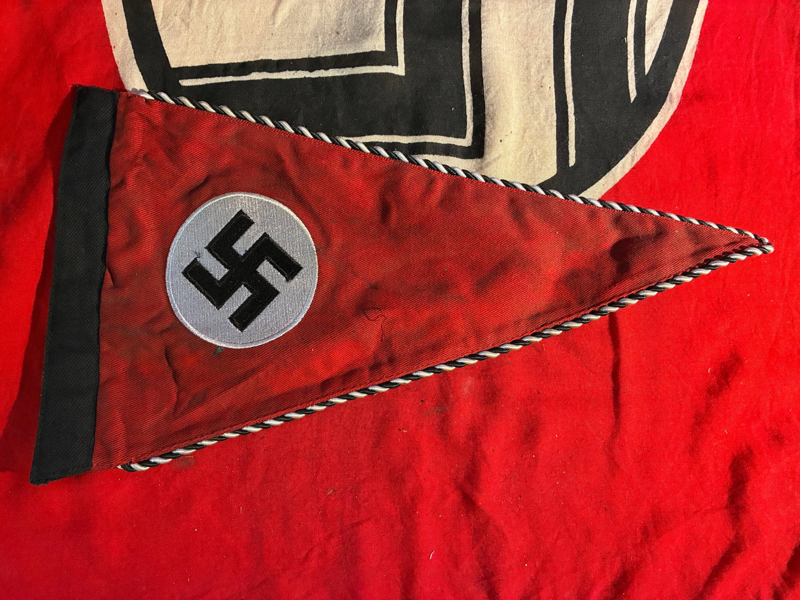WWII GERMAN THIRD REICHS EARLY SS PENNANT FLAG: WWII GERMAN THIRD REICHS EARLY SS PENNANT FLAG. Early flag with alternating white and black striped piping. Multipiece construction. Measures 12 3/4 X 7 1/8 inches. Very good condition.