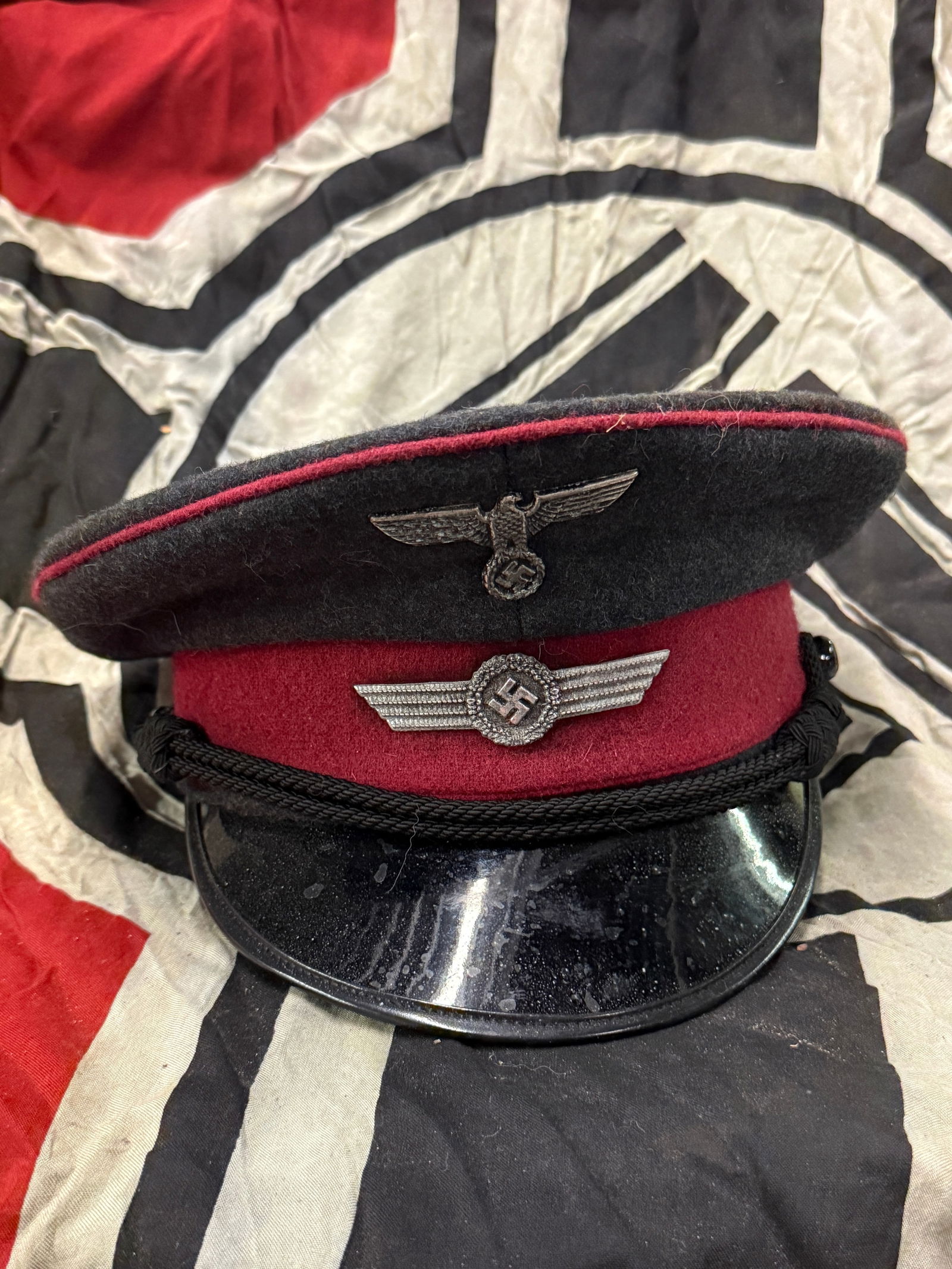 WW2 GERMAN VISOR CAP FOR A LUFTWAFFE ELEVATOR OPERTATOR AND DOORMAN: WW2 GERMAN VISOR CAP FOR A LUFTWAFFE ELEVATOR OPERTATOR AND DOORMAN. A VERY RARE FIND. SHOWS GOOD WEAR AND USE WITH A BEAUTIFUL OVERALL PATINA. Blue-grey wool, Bordeaux-red cloth center band, Bordeaux