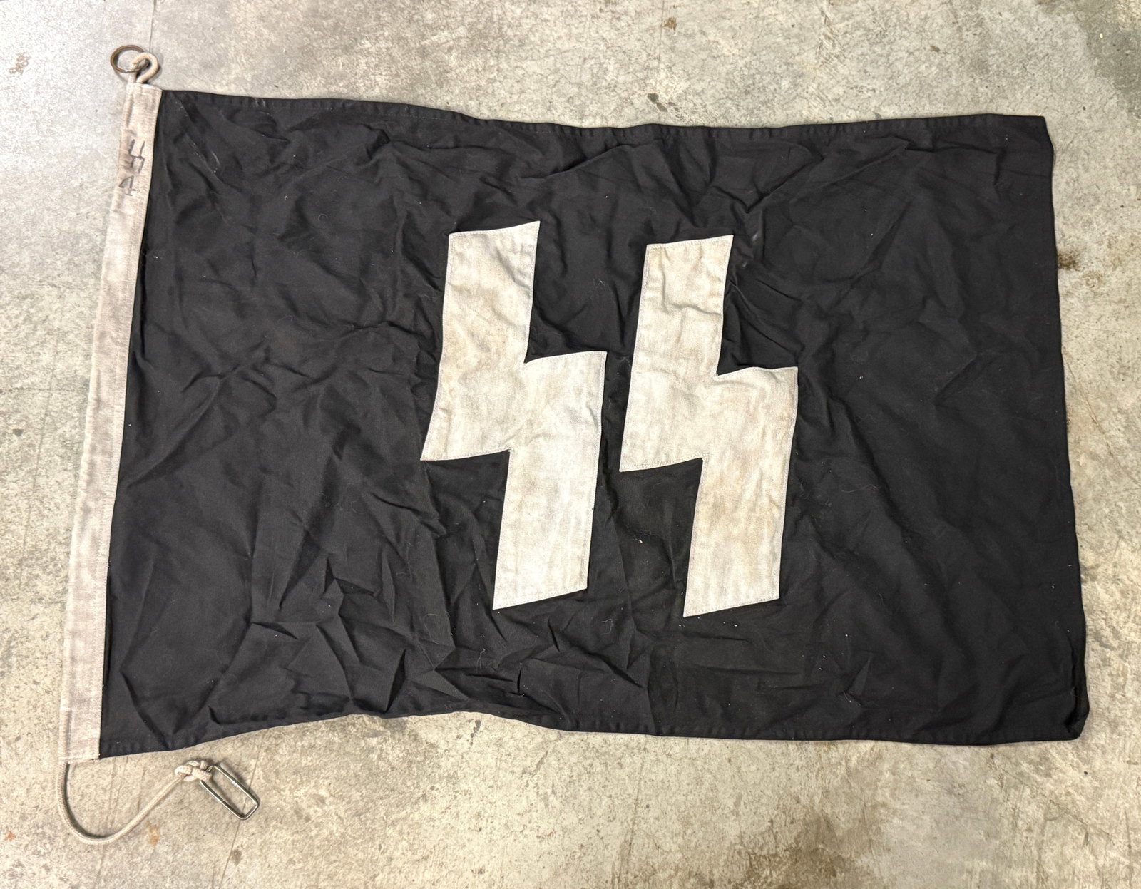WW2 GERMAN WAFFEN SS FLAG ON BLACK FIELD WITH WHITE SS RUNES AND MARKED SS: WW2 GERMAN WAFFEN SS FLAG ON BLACK FIELD WITH WHITE SS RUNES AND MARKED SS. A RARE FIND. SHOWS GOOD WEAR AND USE WITH A BEAUTIFUL OVERALL PATINA. PLEASE VIEW ALL DETAILED PICTURES. A VERY RARE EXAMPLE