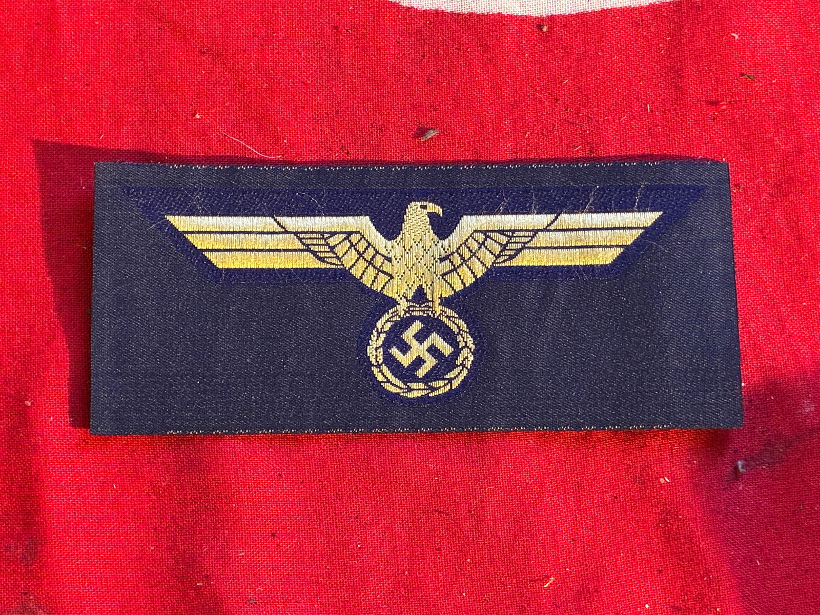 WWII German Kriegsmarine Cap Eagle Bevo: WWII German Kriegsmarine Cap Eagle Bevo. Bevo Yellow cotton woven on dark blue unused as pictured.