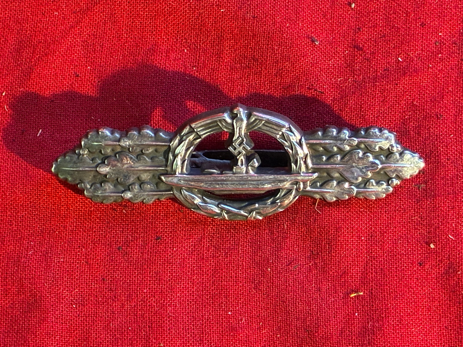 WWII German Naval Submarine Front or Combat Clasp by Schwerin: WWII German Naval Submarine Front or Combat Clasp by Schwerin. Shows good wear and use with a beautiful overall patina. Maker Marked ENTWURF PEEKHAUS AUSF. SCHWERN BERLIN 68 on the reverse. Please vie
