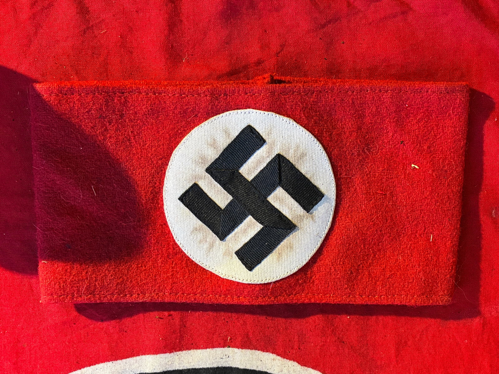 SCARCE WW2 GERMAN NSDAP ARMBAND IN 3 PIECE CONSTRUCTION WITH RZM PAPER TAG: SCARCE WW2 GERMAN NSDAP ARMBAND IN 3 PIECE CONSTRUCTION WITH RZM PAPER TAG. German WWII NSDAP wool armband. This armband is the 3 piece style variety that has a stitched white circular field and a bla