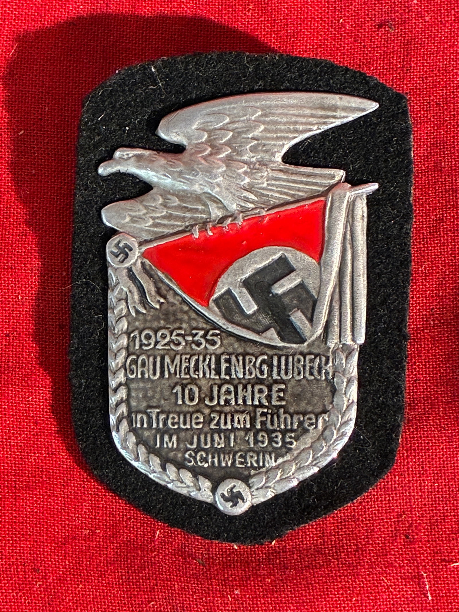 WW2 German N.S.D.A.P. A Gau Mecklenburg-Lübeck 10-Year Anniversary Badge: WW2 German N.S.D.A.P. A Gau Mecklenburg-Lübeck 10-Year Anniversary Badge. A rare find that is in mint overall shape and condition with a beautiful overall patina. Shows good wear and use. Please view