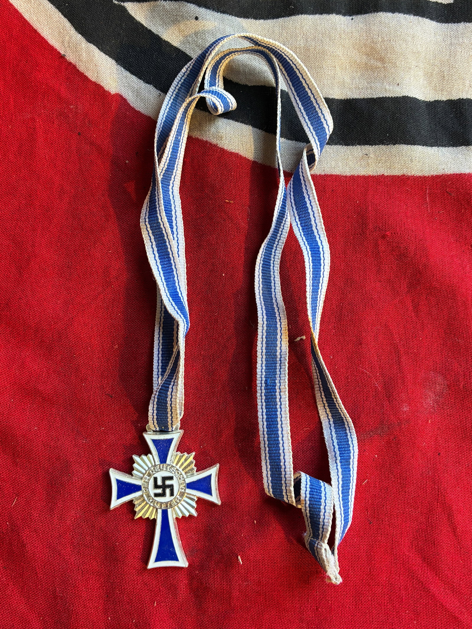 CROSS OF HONOR OF THE GERMAN MOTHER IN SILVER 1938 GERMANY WW2 WITH LONG RIBBON: CROSS OF HONOR OF THE GERMAN MOTHER IN SILVER 1938 GERMANY WW2 WITH LONG RIBBON. This cross was awarded to a mother who have raised 4 children or more. The cross is near mint and have a great enamel a