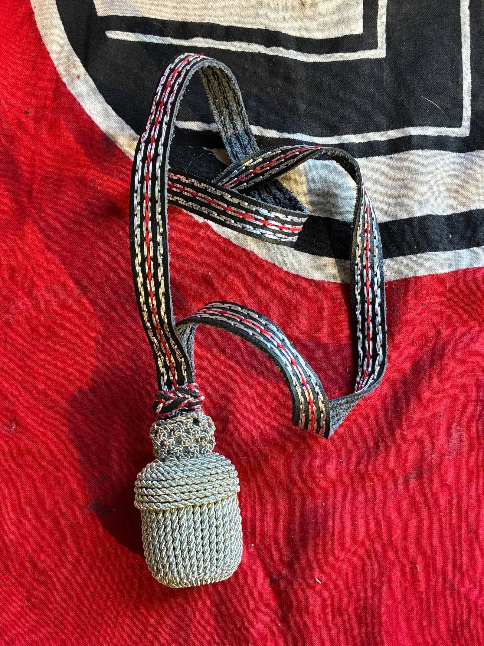 A Second War Period German Sword Portapee: A Second War Period German Sword Portapee. Intricately patterned with rows of silver bullion and green embroidery, green embroidered head, wrapped around an aluminum frame, with stem, measuring 31 mm 