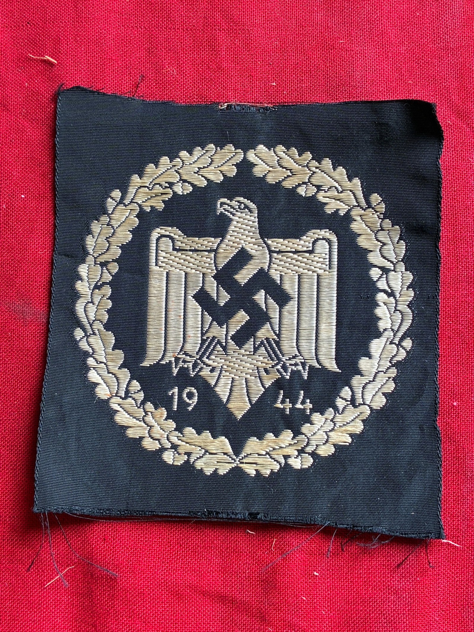 WW2 GERMAN NSRL/DRL SILVER SPORTS BADGE IN CLOTH: WW2 GERMAN NSRL/DRL SILVER SPORTS BADGE IN CLOTH. This cloth version of the award, which would have been sewn to an athletic uniform, has, machine woven in silver-colored threads to its black rayon ba