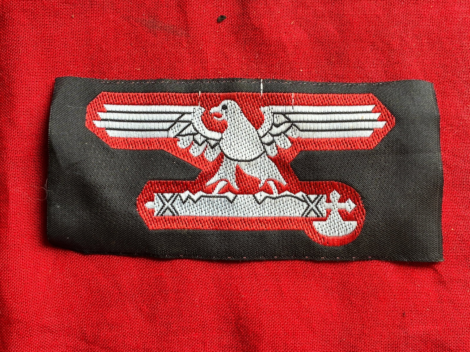 A WW2 GERMAN FASCIST ITALIAN WWII SS SLEEVE EAGLE PATCH: A WW2 GERMAN FASCIST ITALIAN WWII SS SLEEVE EAGLE PATCH. A fascist Italian WWII SS sleeve patch with eagle embroidered in white and red threads on a black cloth.