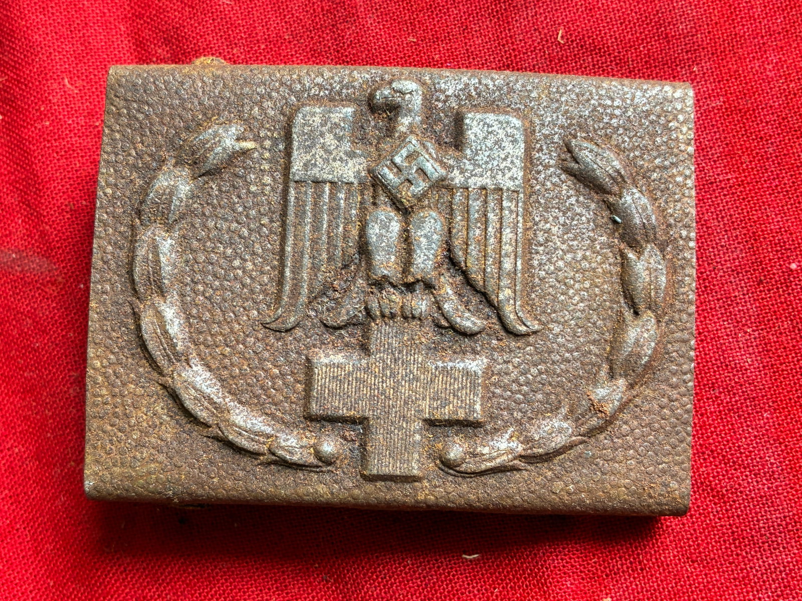 WWII GERMAN THIRD REICH RED CROSS BELT BUCKLE: WWII GERMAN THIRD REICH RED CROSS BELT BUCKLE. The front shows a German eagle clutching a Red Cross emblem in his talons. There is a swastika in the center of his chest. All three are surrounded by an