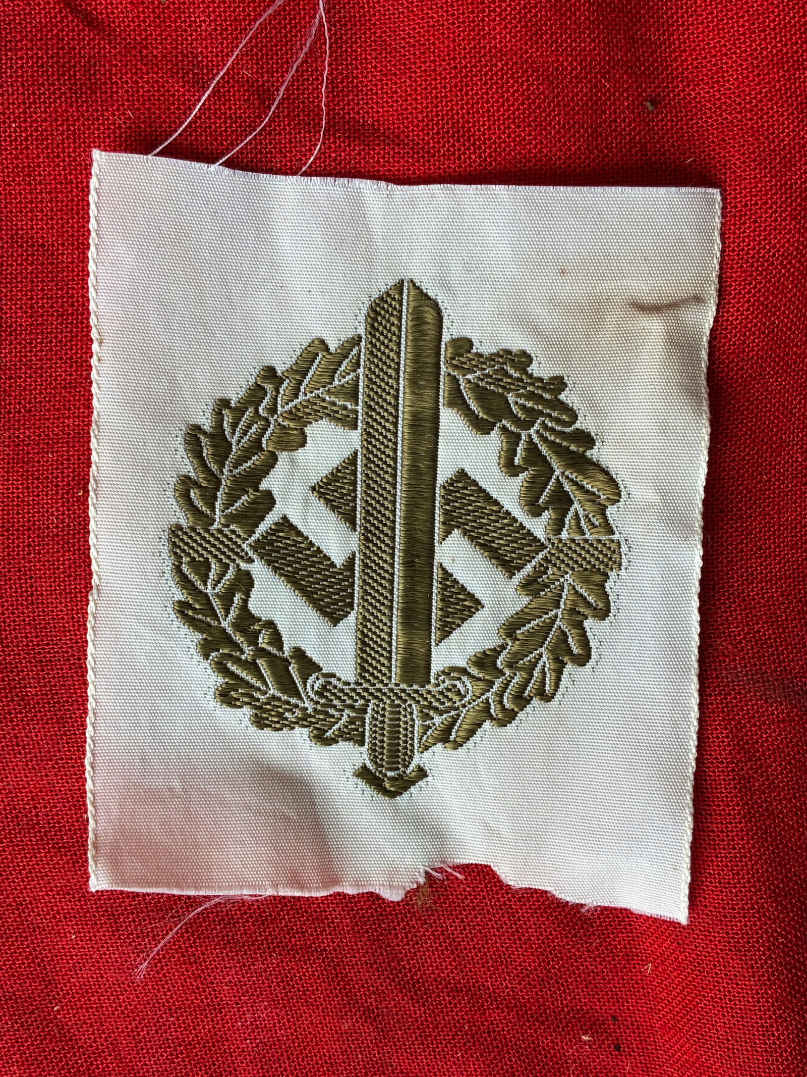 WW2 German Bronze Grade SA Sports Badge in Cloth: WW2 German Bronze Grade SA Sports Badge in Cloth. A scarce fine quality SA Sports Badge constructed in a detailed bronze-coloured machine embroidery on a white rayon background. A rare find of the tim