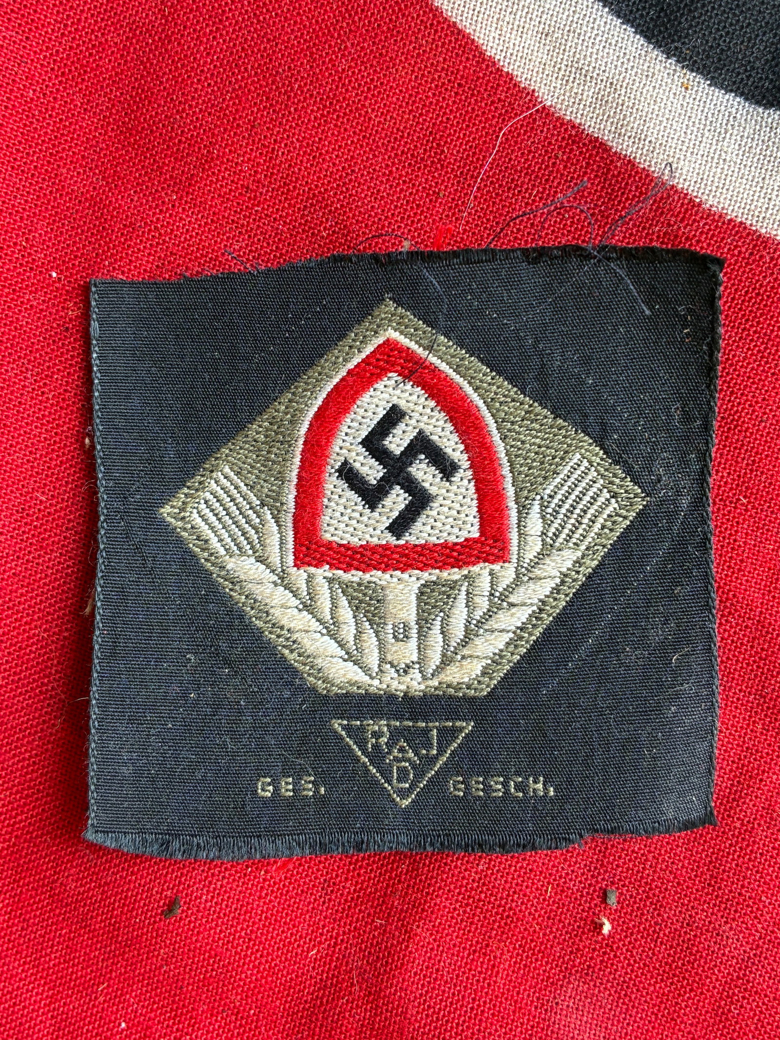 WW2 German RAD Flat Wire Cap Cloth Insignia: WW2 German RAD Flat Wire Cap Cloth Insignia. Has the Ges. Gesch. Maker marks. Unissued example that is in mint condition with storage patina. Please view all detailed pictures. A rare find.