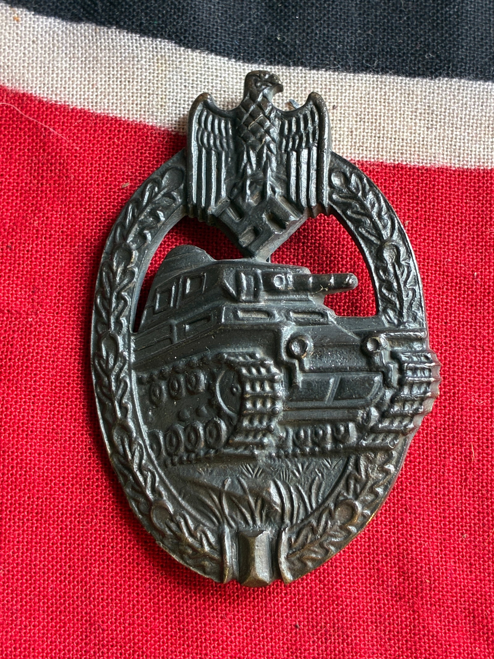 WW2 German Panzer Tank assault badge in silver: WW2 German Panzer Tank assault badge in silver. Mid to late war zinc PAB with Vienna design front. Remains in good appealing condition with some of the finish worn down on the front and the rest faded