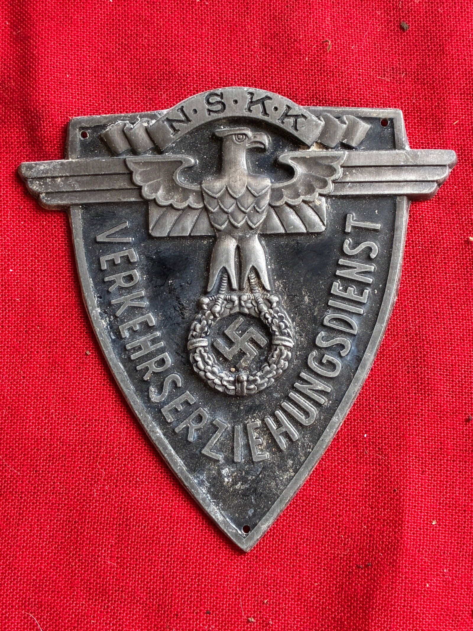 German WWII NSKK Traffic Education Sleeve Shield: German WWII NSKK Traffic Education Sleeve Shield. Well made, curved aluminum sleeve shield with mounting holes in each corner. Shows good wear and use with a beautiful overall patina. Please view all 