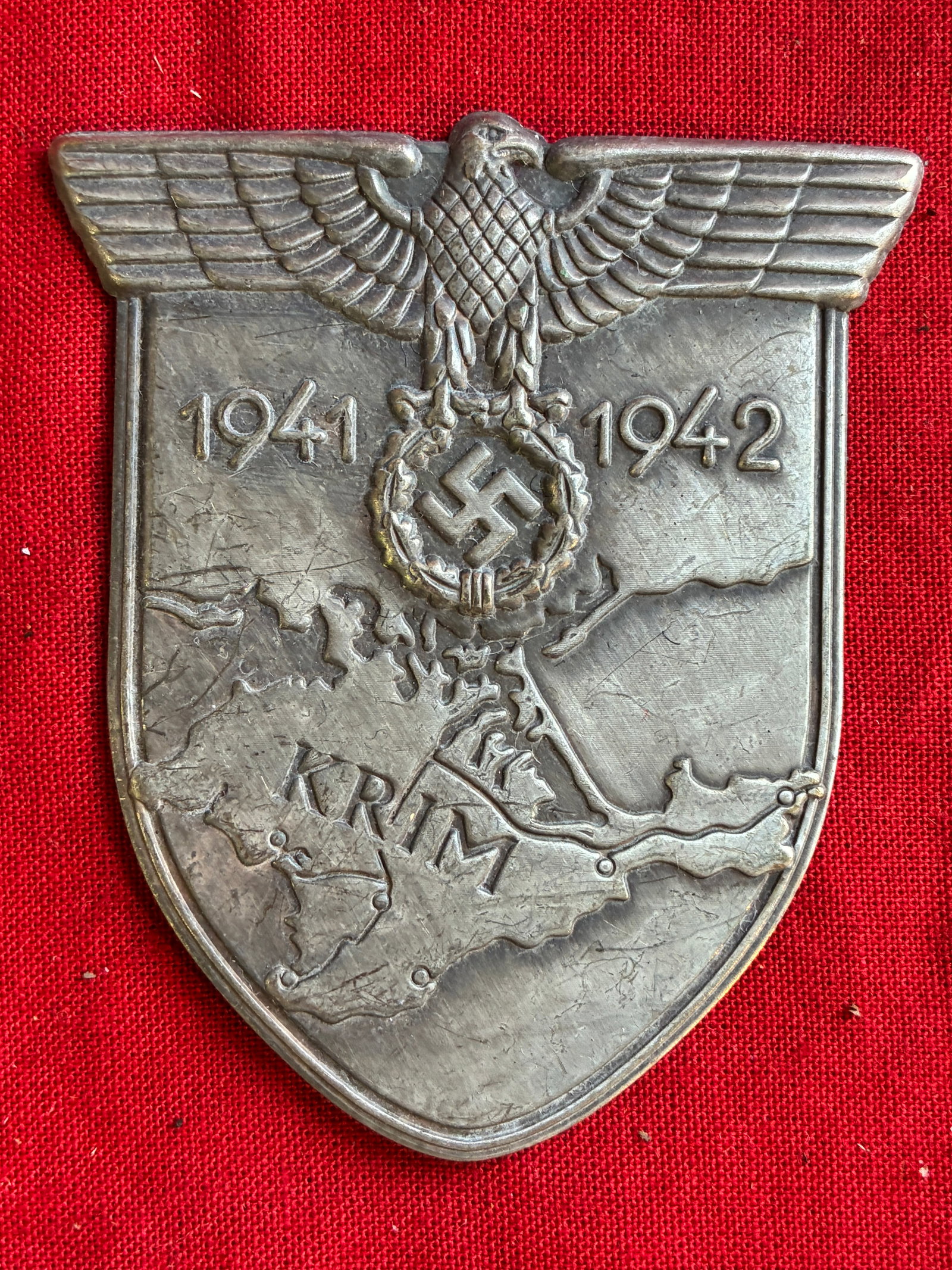 RARE WW2 GERMAN KRIM SLEEVE SHIELD IN ZINC: RARE WW2 GERMAN KRIM SLEEVE SHIELD IN ZINC. A RARE FIND. NO MISSING PRONGS ON THE REVERSE. SHOWS GOOD WEAR AND USE WITH A BEAUTIFUL PATINA THROUGHOUT. PLEASE VIEW ALL DETAILED PICTURES. A WELL MADE AN