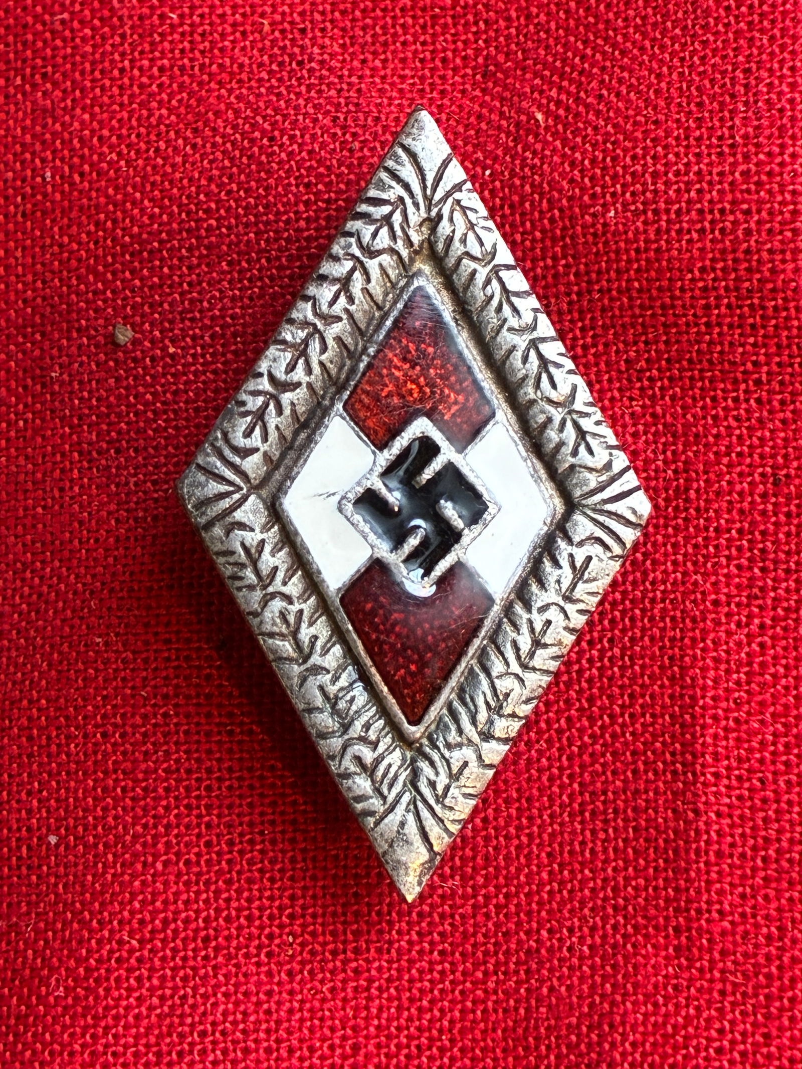 WWII GERMAN THIRD REICH GOLD HITLER YOUTH BADGE: Red, white, and black enamel with gold toned oak leaf border. Reverse is not marked. Measures 1 1/2 inche
