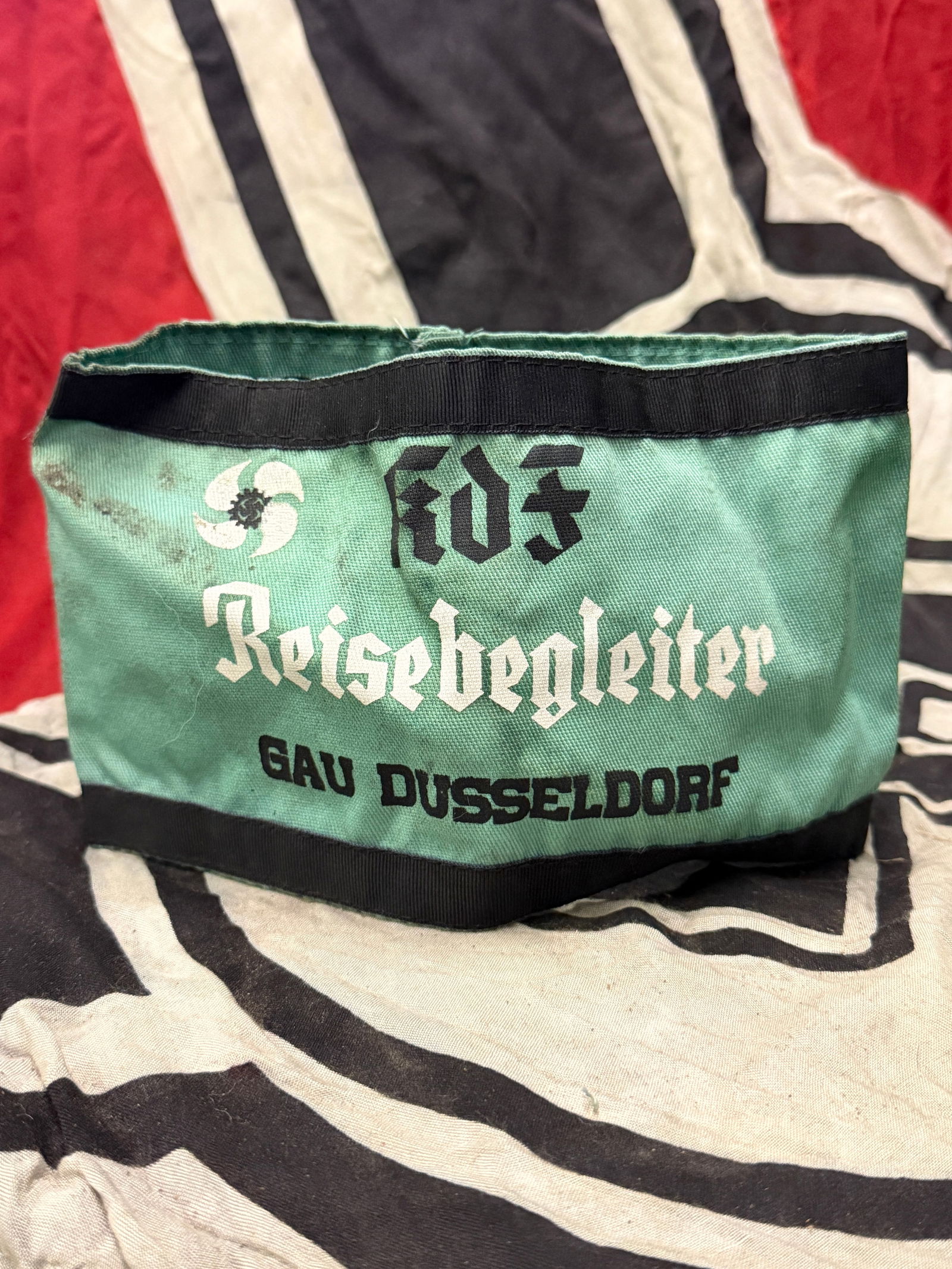WW2 GERMAN KDF REISEBEGLEITER GAU DUSSELDORF ARMBAND WITH RZM PAPER TAG: WW2 GERMAN KDF REISEBEGLEITER GAU DUSSELDORF ARMBAND WITH RZM PAPER TAG. A VERY RARE EXAMPLE. SHOWS GOOD WEAR AND USE WITH A BEUATIFUL OVERALL PATINA. PLEASE VIEW ALL DETAILED PICTURES. A RARE EXAMPLE